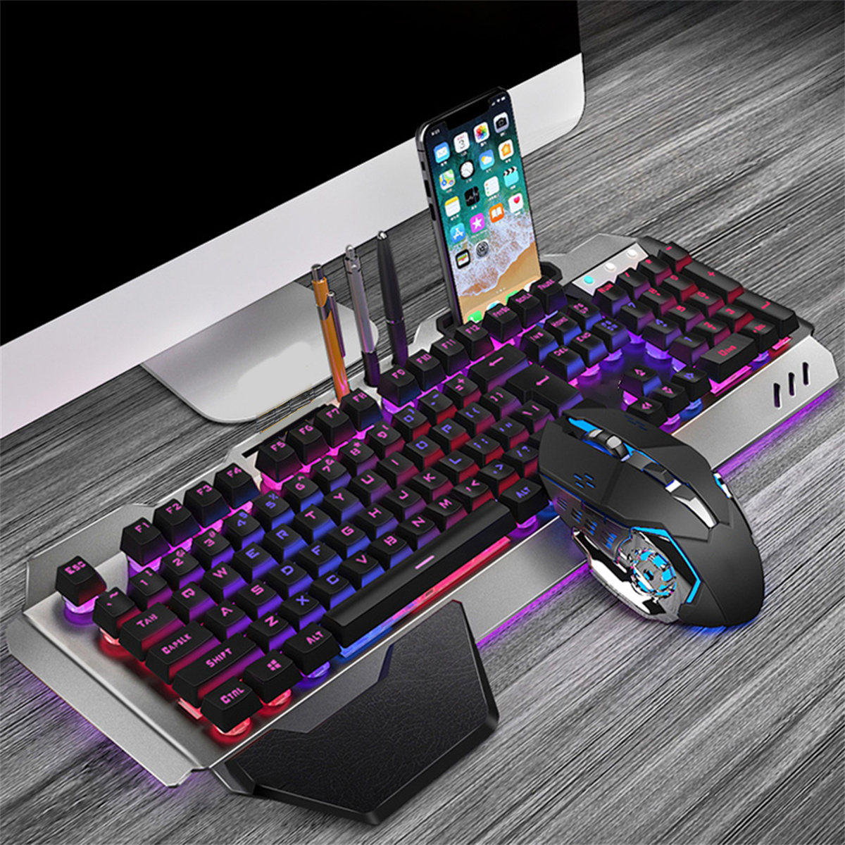 Eine Gaming-Tastatur, Maus und Telefon. Die Tastatur hat RGB-Beleuchtung. Telefon zeigt eine App an.