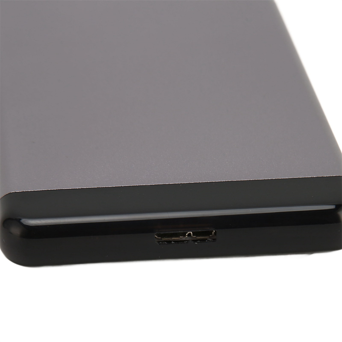 Graue, rechteckige externe Festplatte. Verfügt über einen USB-Anschluss auf einer der kurzen Seiten.