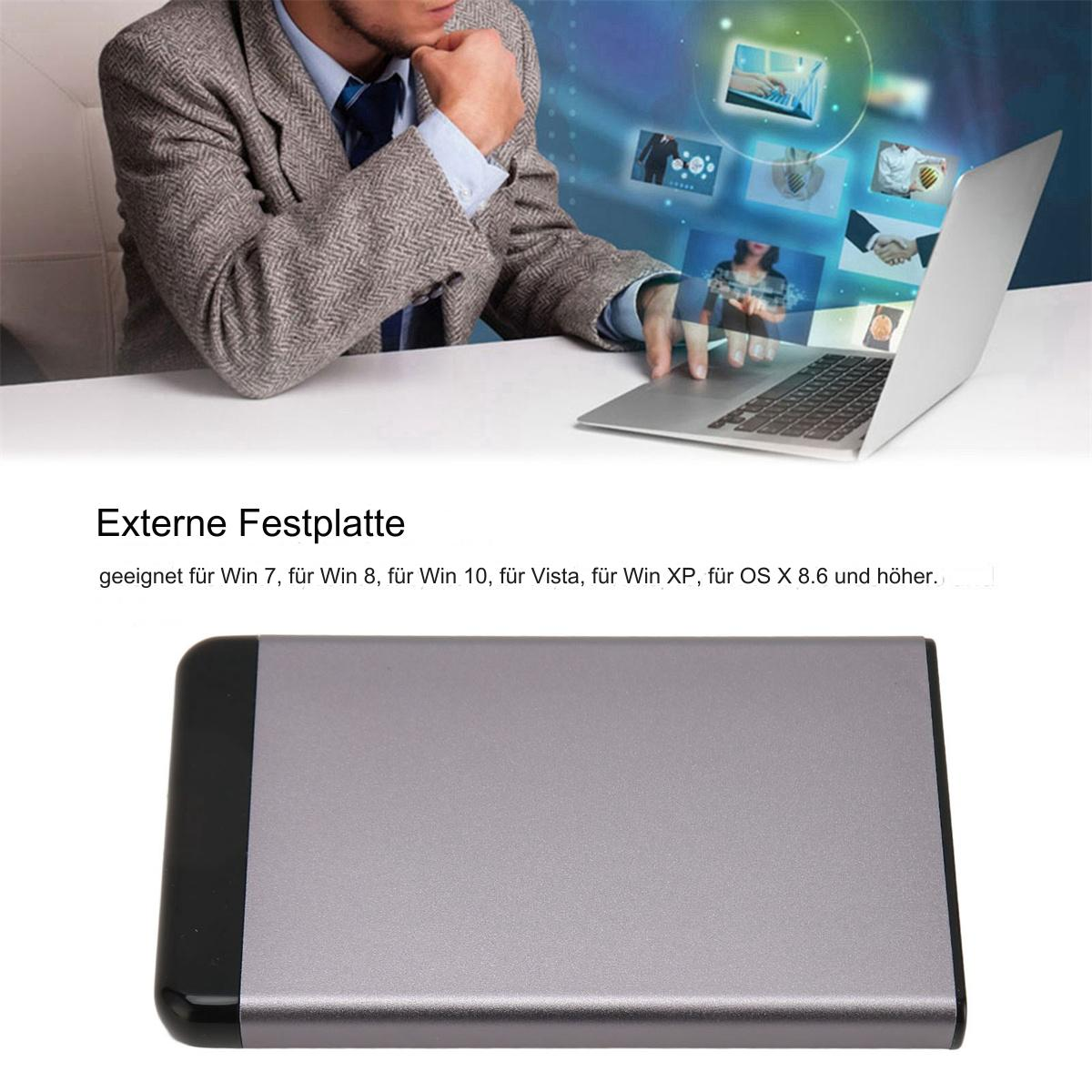 Silberne externe Festplatte mit schwarzem Ende, neben einer Person, die einen Laptop benutzt.