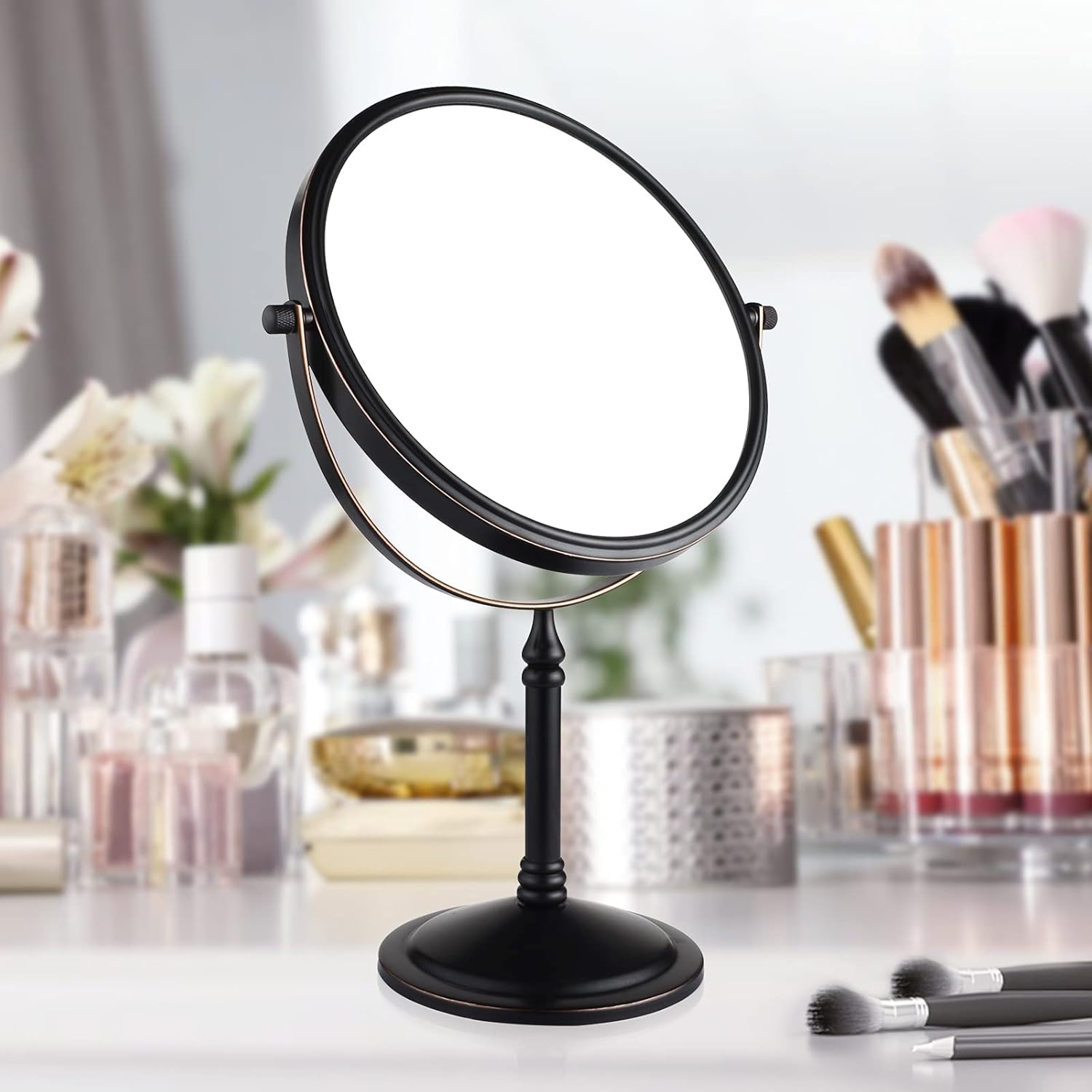Runder, schwarz gerahmter Schminkspiegel auf einem Ständer. Make-up-Pinsel und Flaschen sind im Hintergrund.
