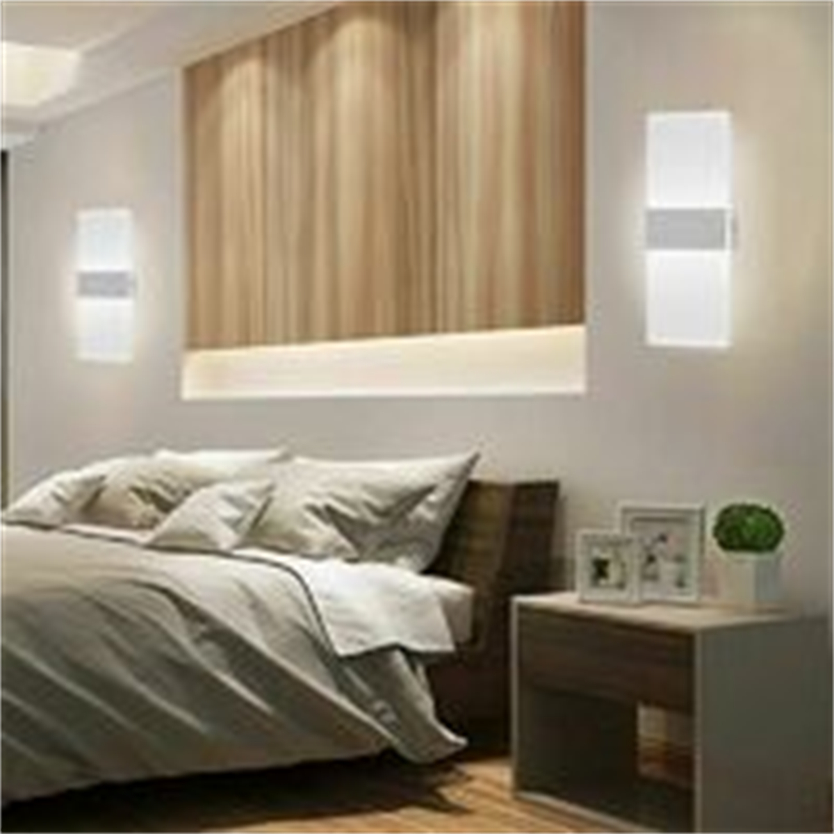 Schlafzimmer mit zwei Wandleuchten und einem Bett mit Kissen und Nachttisch.