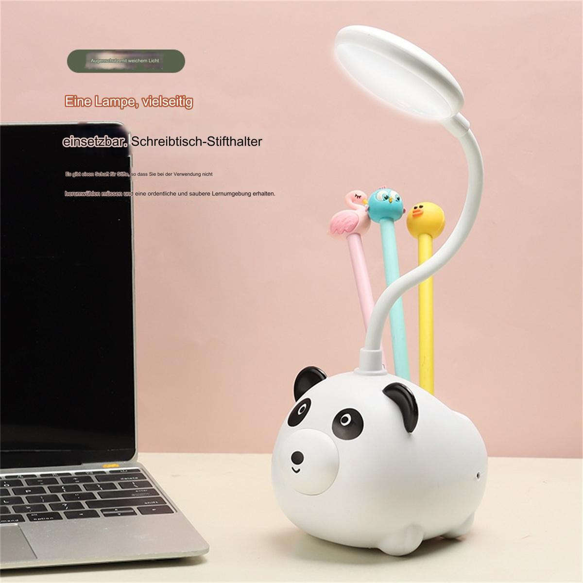 Eine weiße, panda-förmige Schreibtischlampe mit Stifthalter, Stiften und einem Laptop auf rosa Oberfläche.