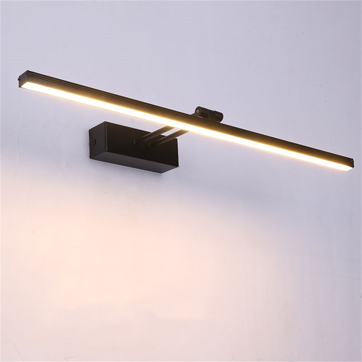 Eine schwarze, rechteckige Wand-Bildleuchte, die helles Licht auf eine weiße Wand wirft.