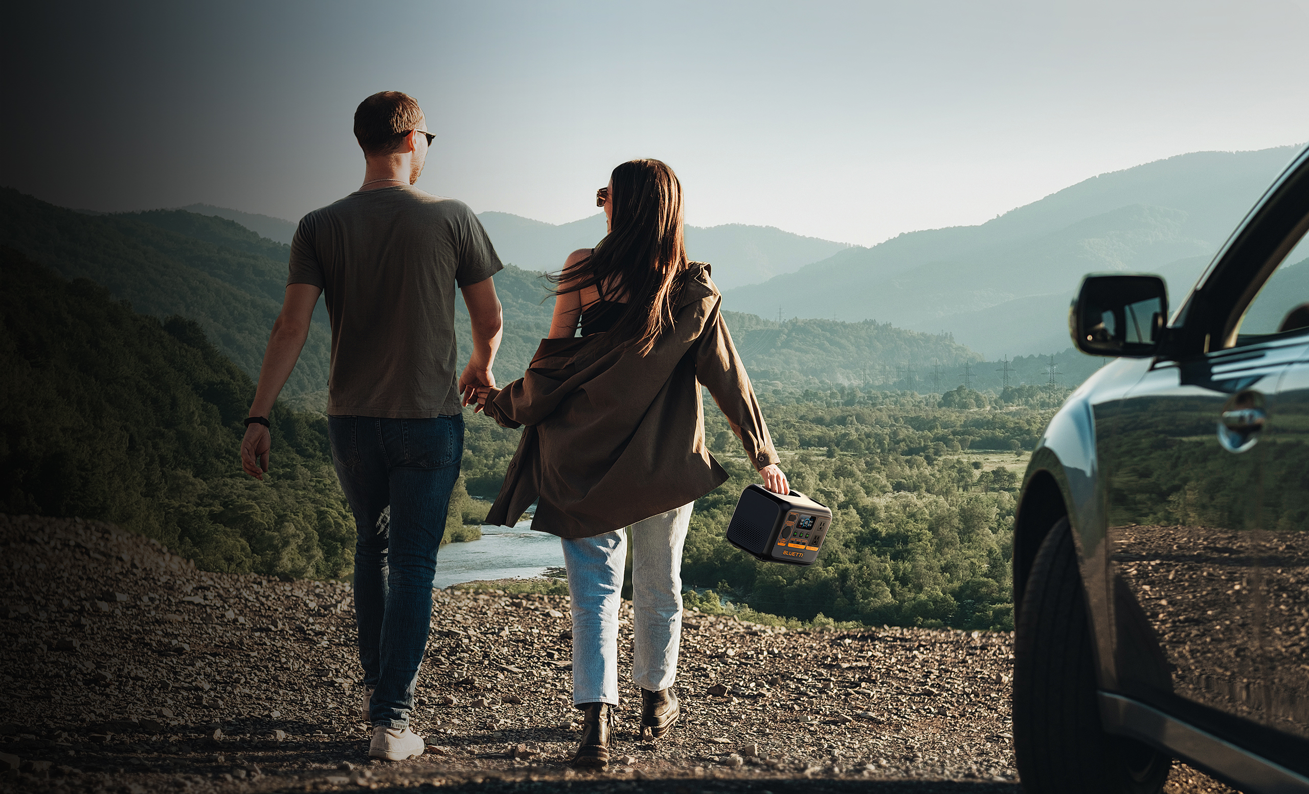 Para idzie za rękę w kierunku gór. Samochód po prawej. Radio. Zielone i niebieskie tony.