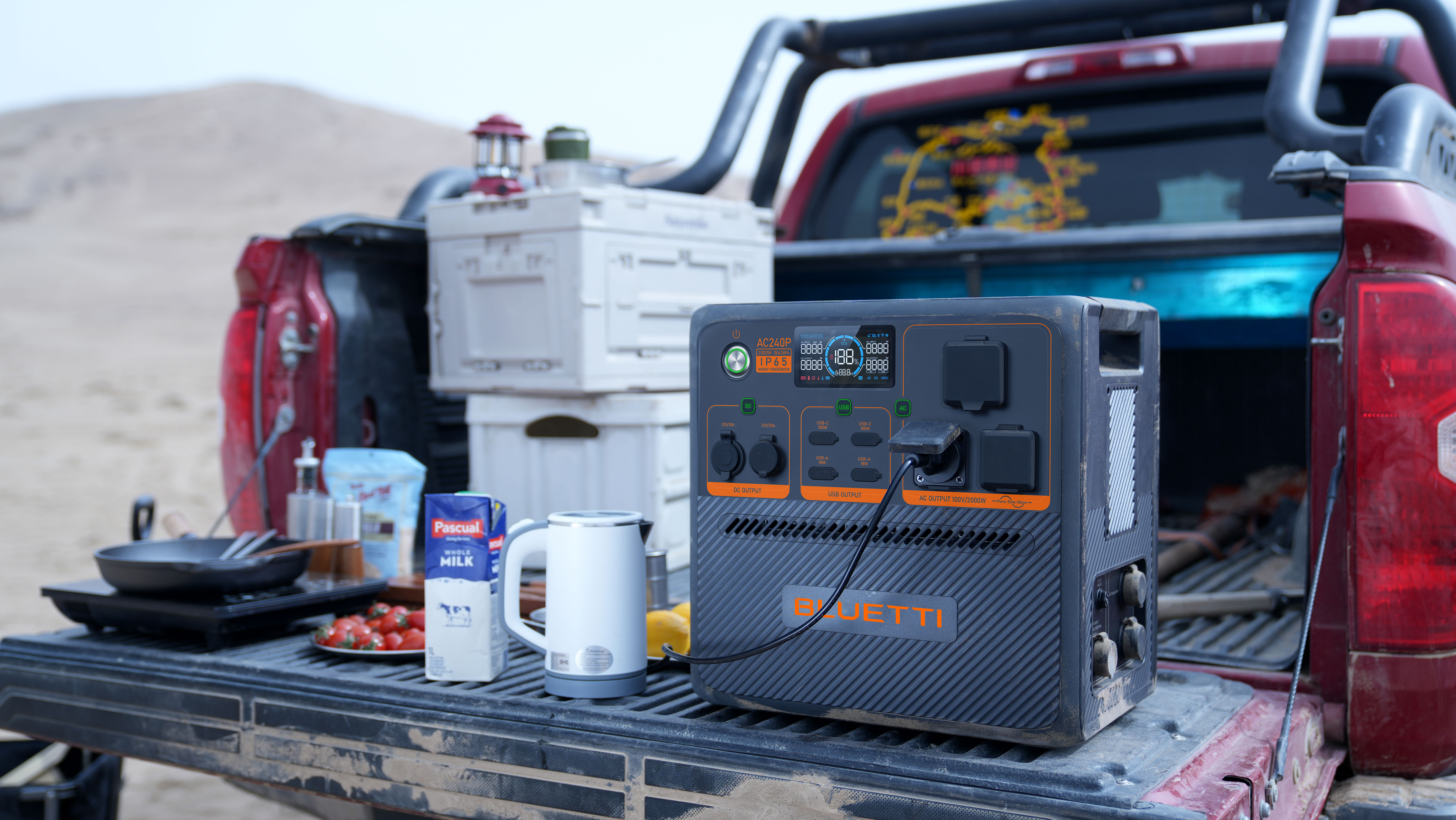 Generator na pace ciężarówki w krajobrazie pustynnym. Jest czajnik, mleko i przybory kuchenne.