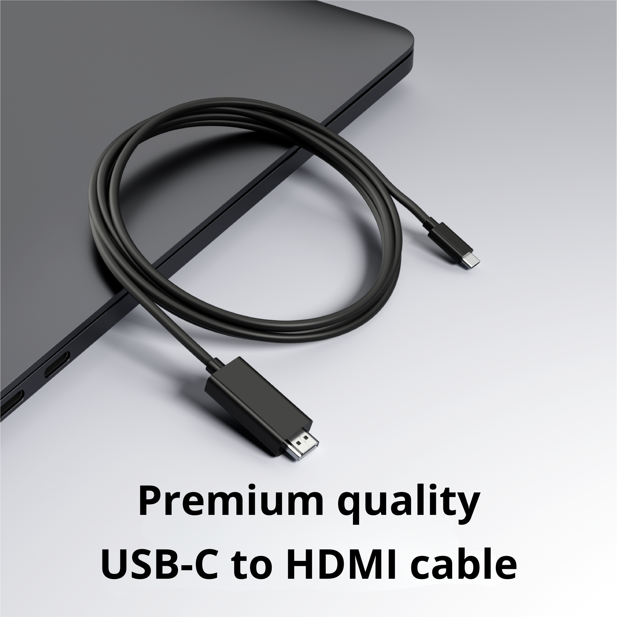 Zwarte USB-C naar HDMI-kabel, opgerold op een grijs oppervlak, met een laptop op de achtergrond.
