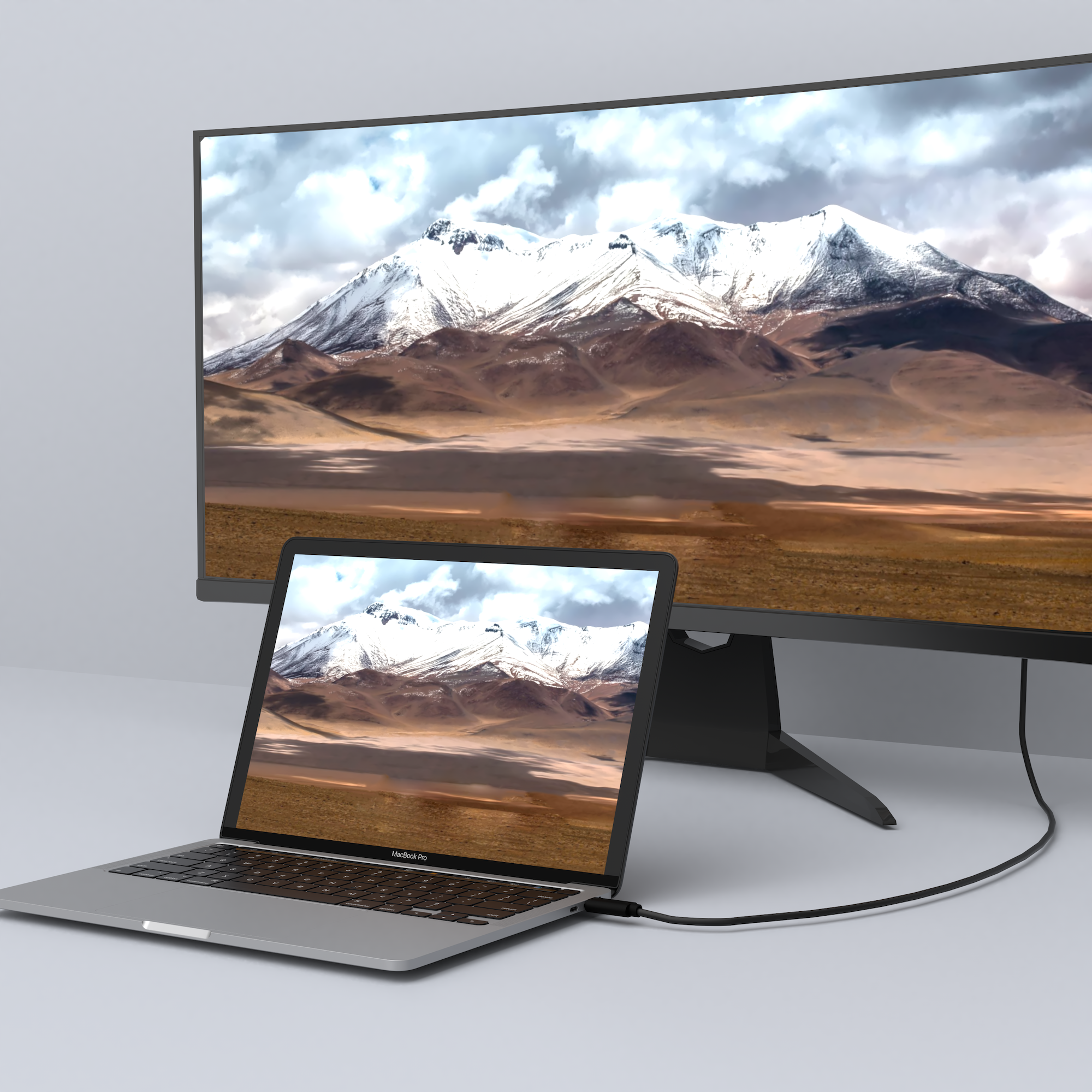 Laptop aangesloten op een monitor met een berglandschap.