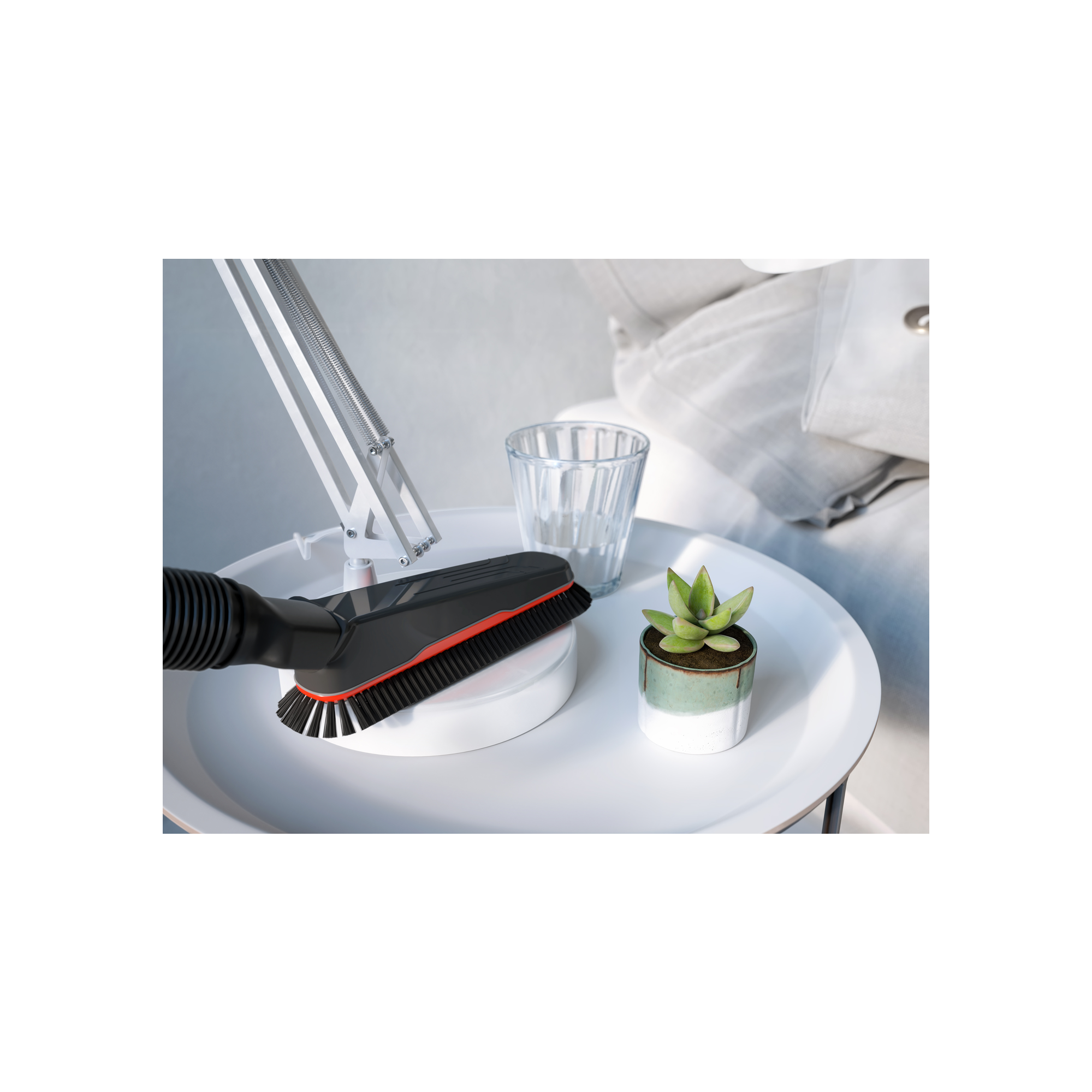 Tavolo bianco con piccola pianta, bicchiere e accessorio per aspirapolvere. Luce intensa.