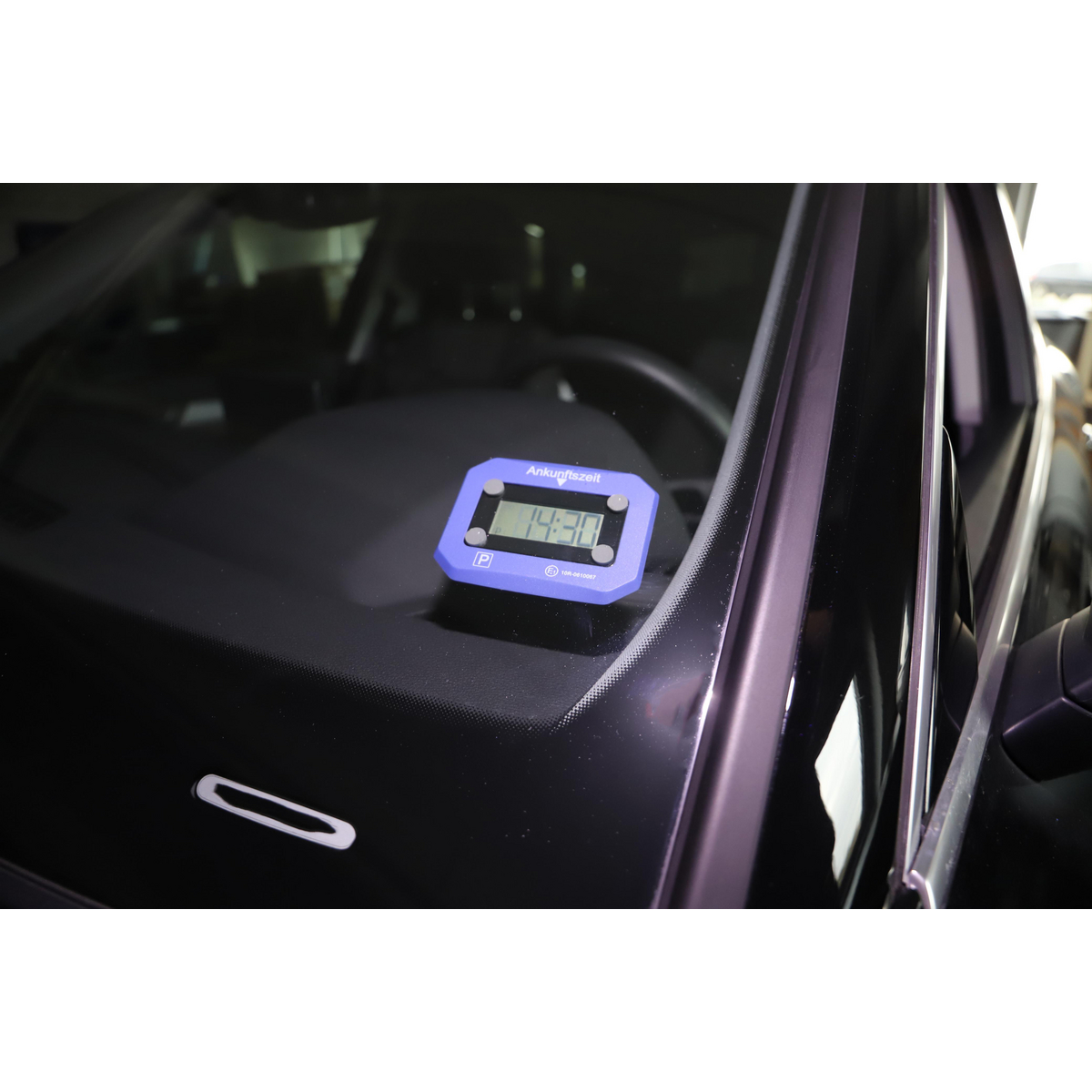 Ein blauer Parkuhr-Timer in einem Auto. Die Zeit wird als 14:30 auf dem Bildschirm angezeigt.