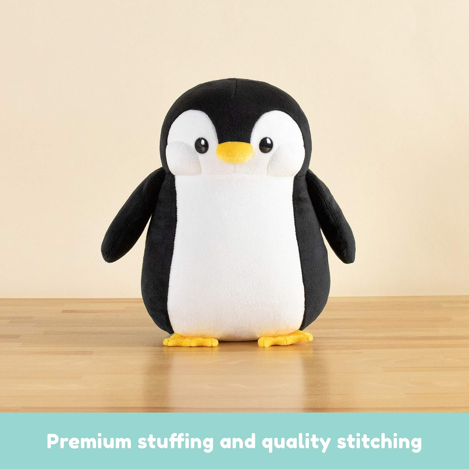 Stoffpinguin, schwarz-weiß, mit gelben Füßen.