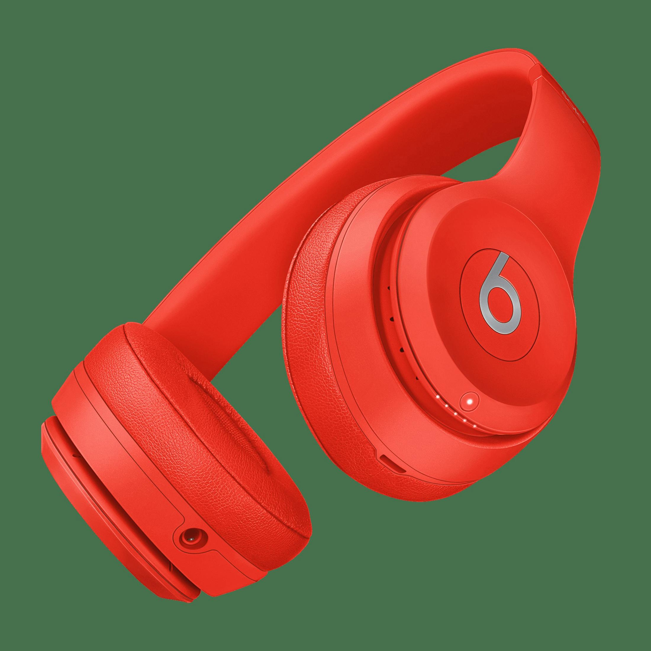 Rote Beats-Kopfhörer auf grünem Hintergrund. Die Kopfhörer sind abgewinkelt und zeigen das 'b'-Logo.