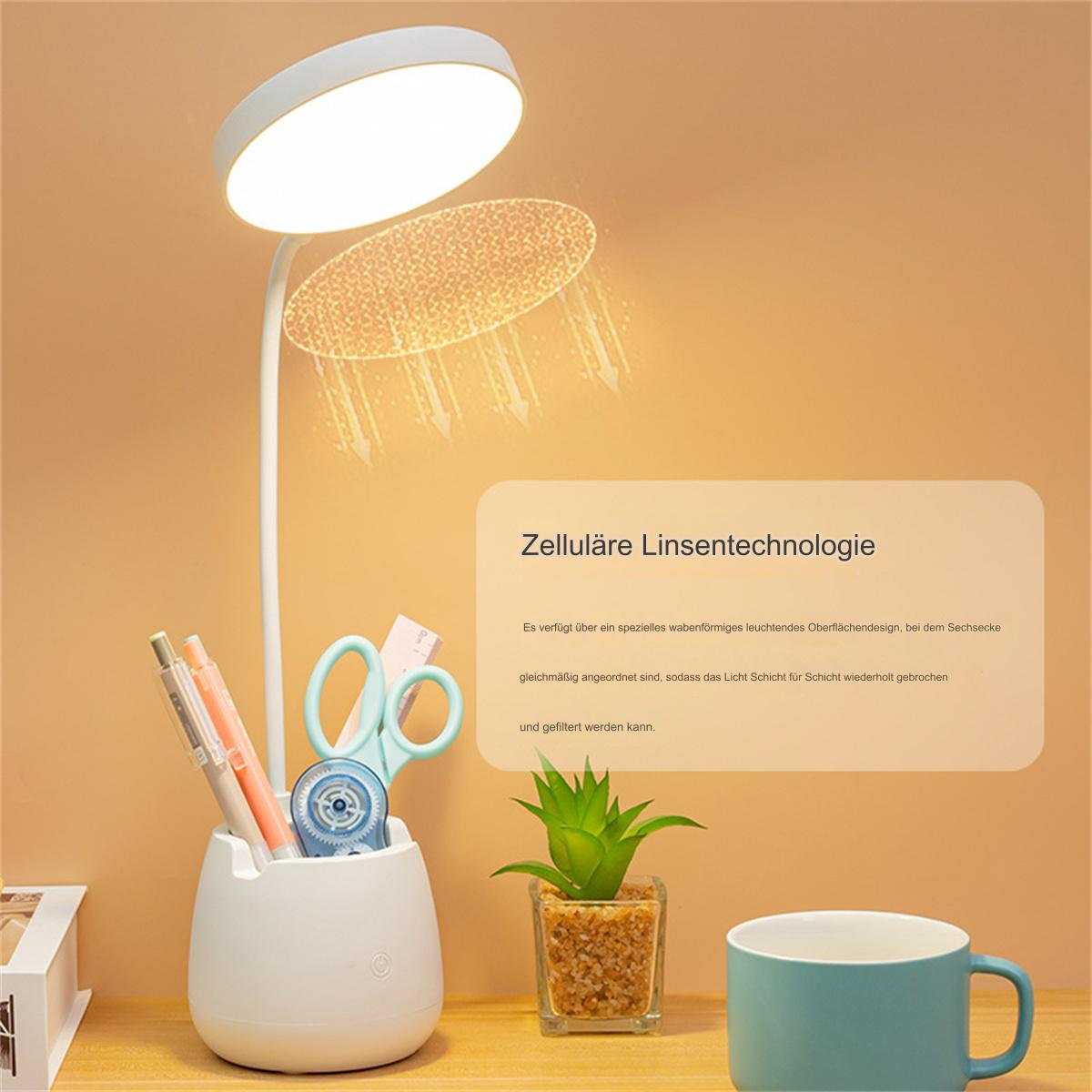 Schreibtisch mit Lampe, Stiften, Schere, kleiner Pflanze und Tasse.