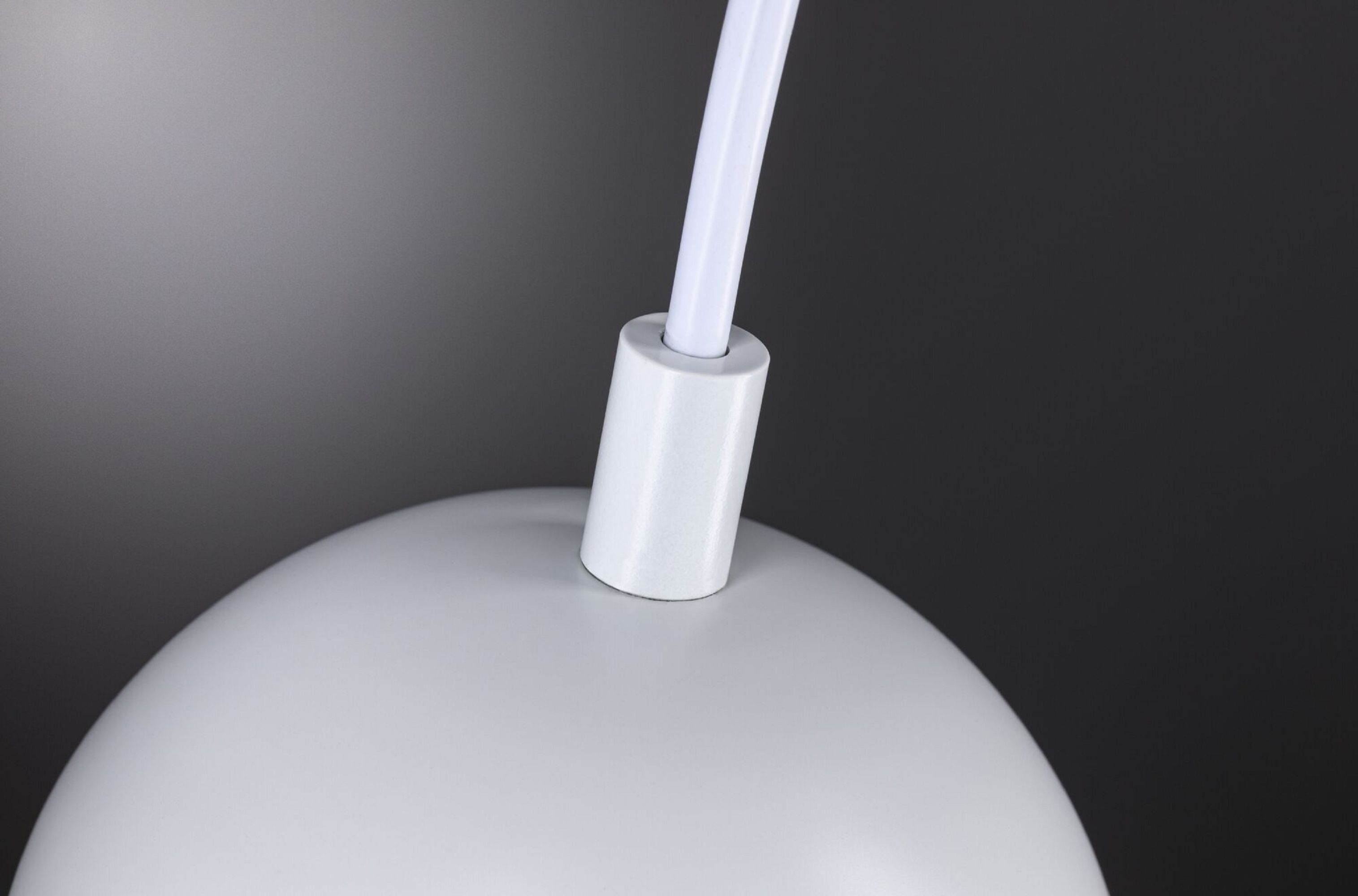 Weiße, runde Pendelleuchte. Das Licht hängt an einem weißen Kabel.