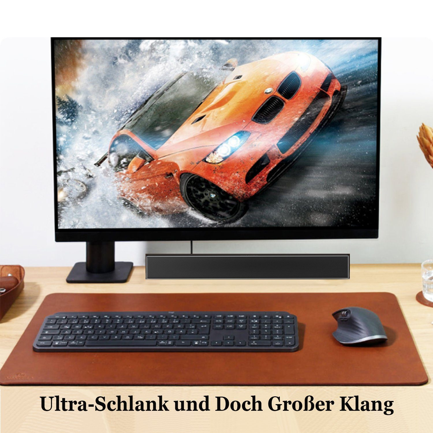 Ein Computer-Setup mit einem Monitor, der ein Autobild anzeigt. Eine Tastatur und Maus stehen auf einem braunen Schreibtisch.