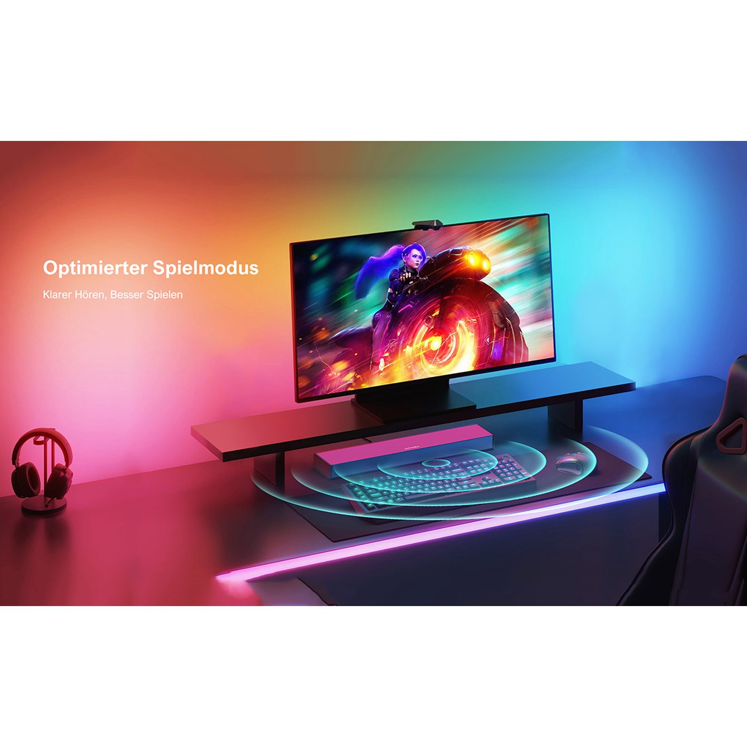 Gaming-Setup mit Monitor, Kopfhörern und Tastatur. Bunte Lichter auf dem Schreibtisch. Schwarzer Stuhl.