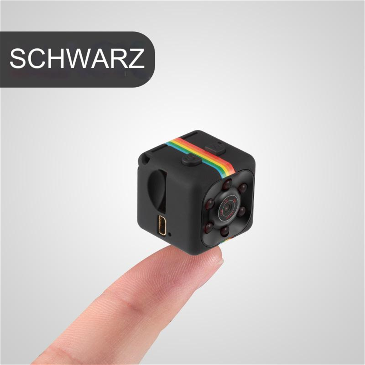 Schwarze Würfelkamera, Regenbogenstreifen, Finger hält, SCHWARZ-Text, heller Hintergrund.