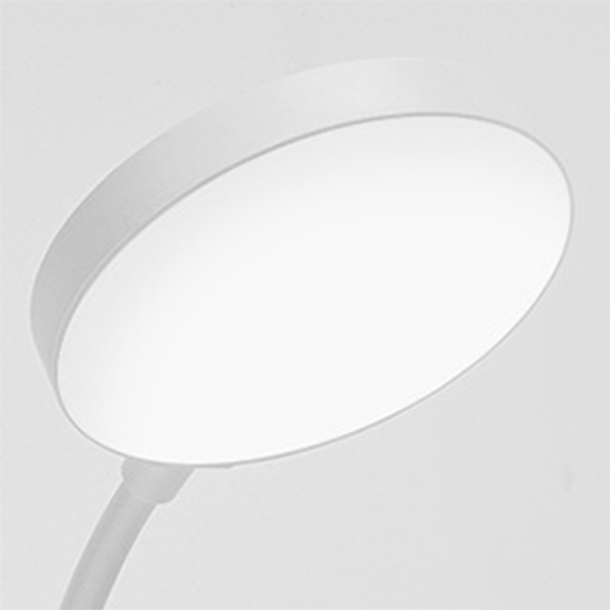 Eine weiße, kreisförmige LED-Schreibtischlampe, die helles Licht ausstrahlt.