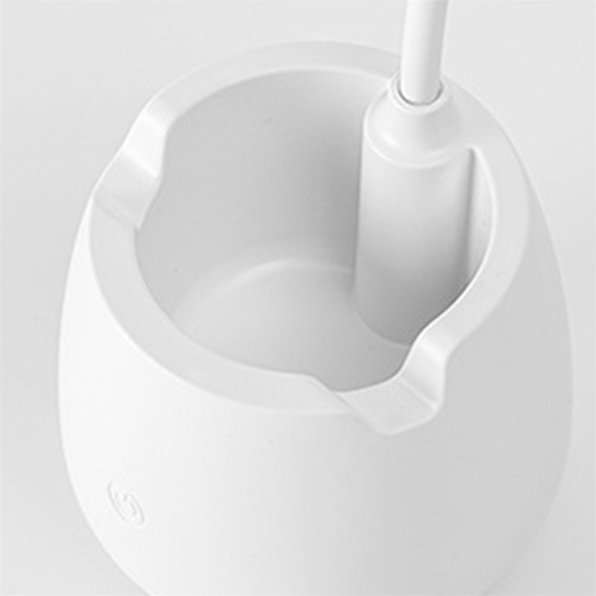 Ein weißer Aschenbecher mit einem zylindrischen Halter für ein Licht auf einer weißen Oberfläche.