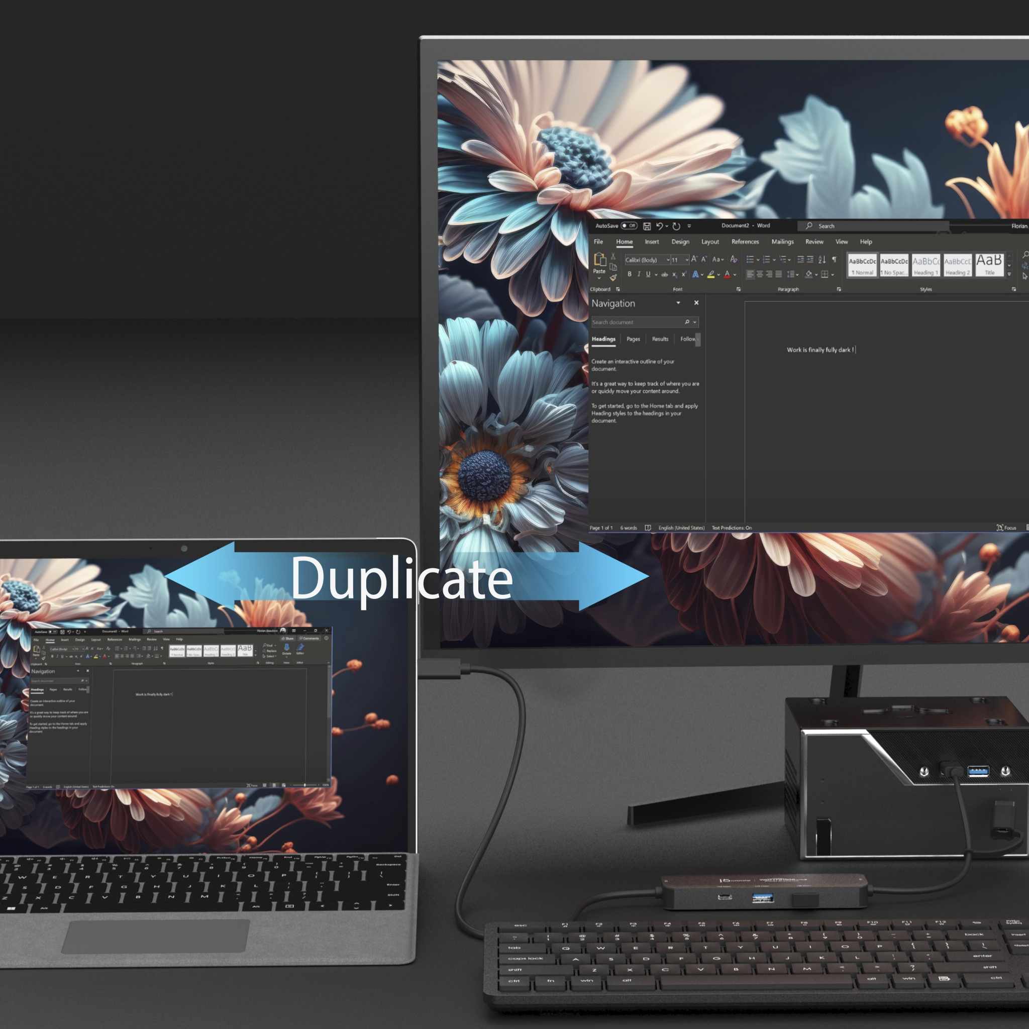 Un laptop duplica lo schermo su un monitor, collegato a un hub e a una tastiera.