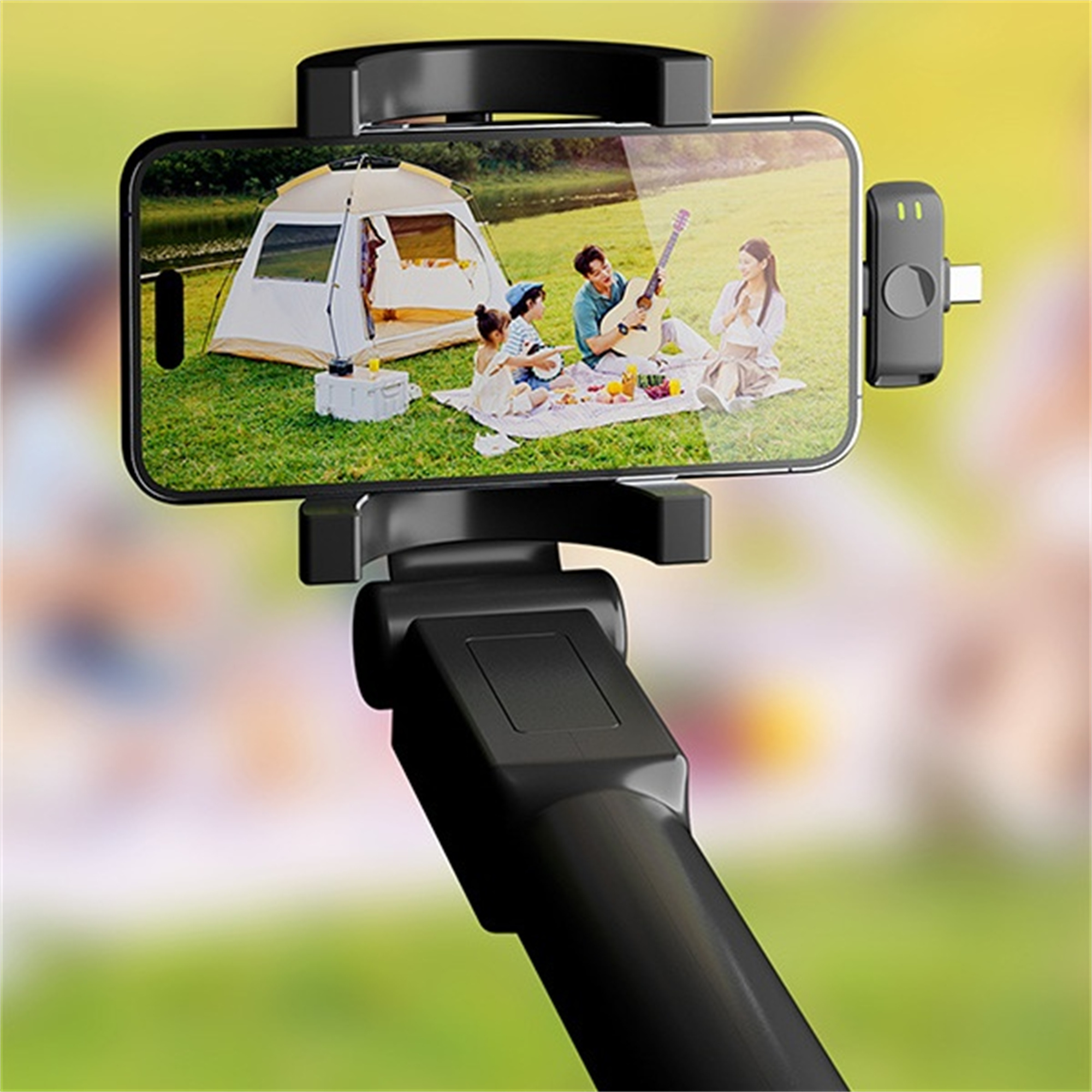 Ein Telefon auf einem Selfie-Stick, das eine Familienszene zeigt, und ein Mikrofon.