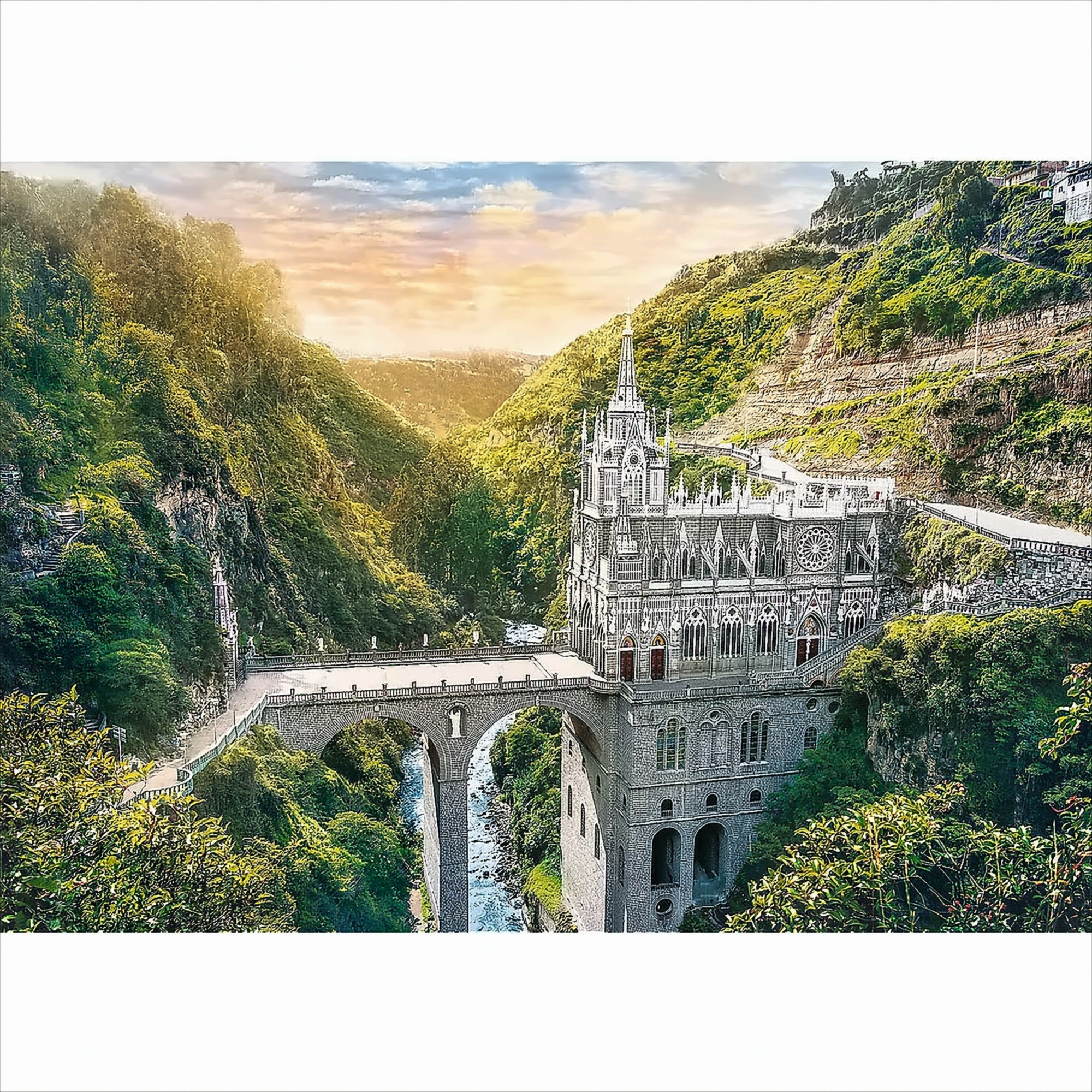 Una vista panorámica de una iglesia con un puente sobre un río, enclavada en un valle, bajo un cielo al atardecer.