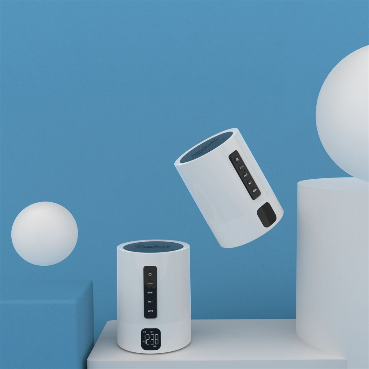 Zwei weiße zylindrische Lautsprecher auf weißer Oberfläche vor blauem Hintergrund mit weißen Kugeln.