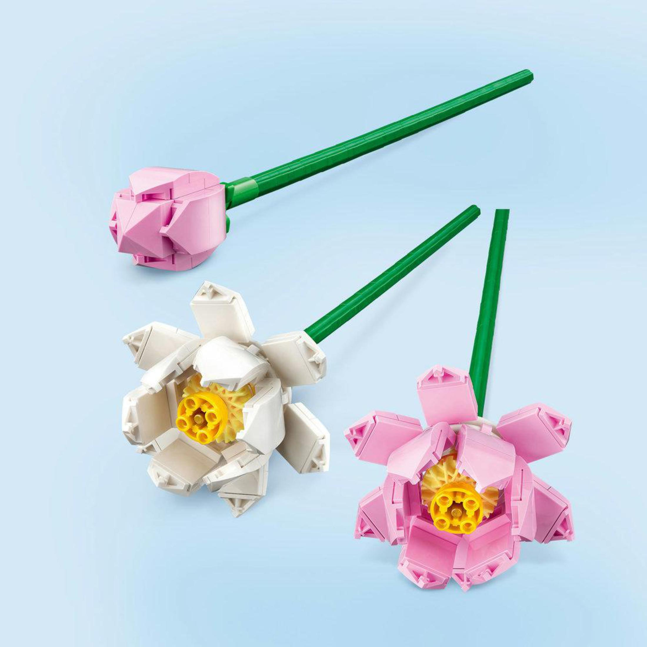 Tre fiori Lego. Uno rosa, uno bianco e uno rosa con centro giallo.