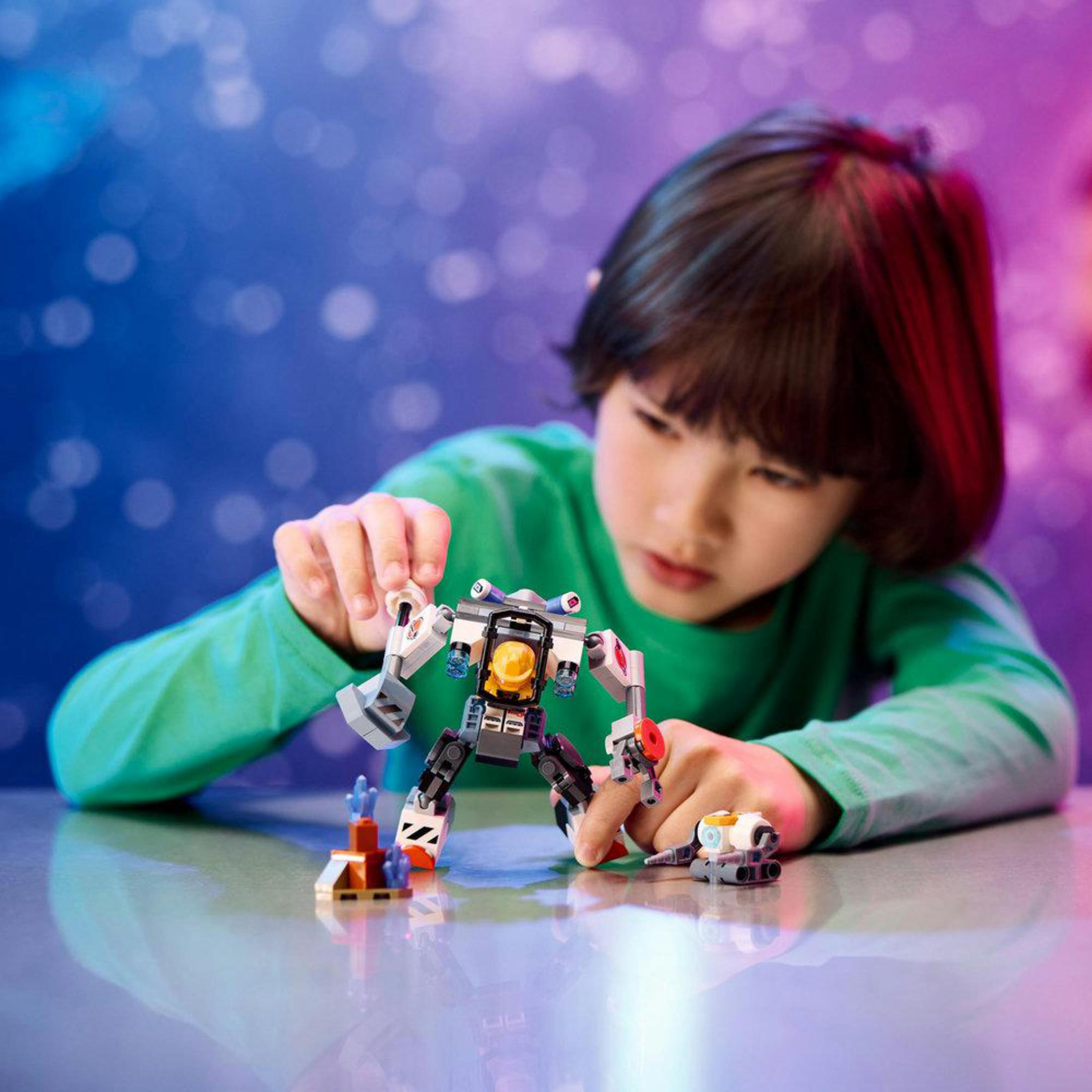 Bir çocuk, renkli bir ortamda parçaları birleştirerek Lego robot oyuncağı ile oynuyor.