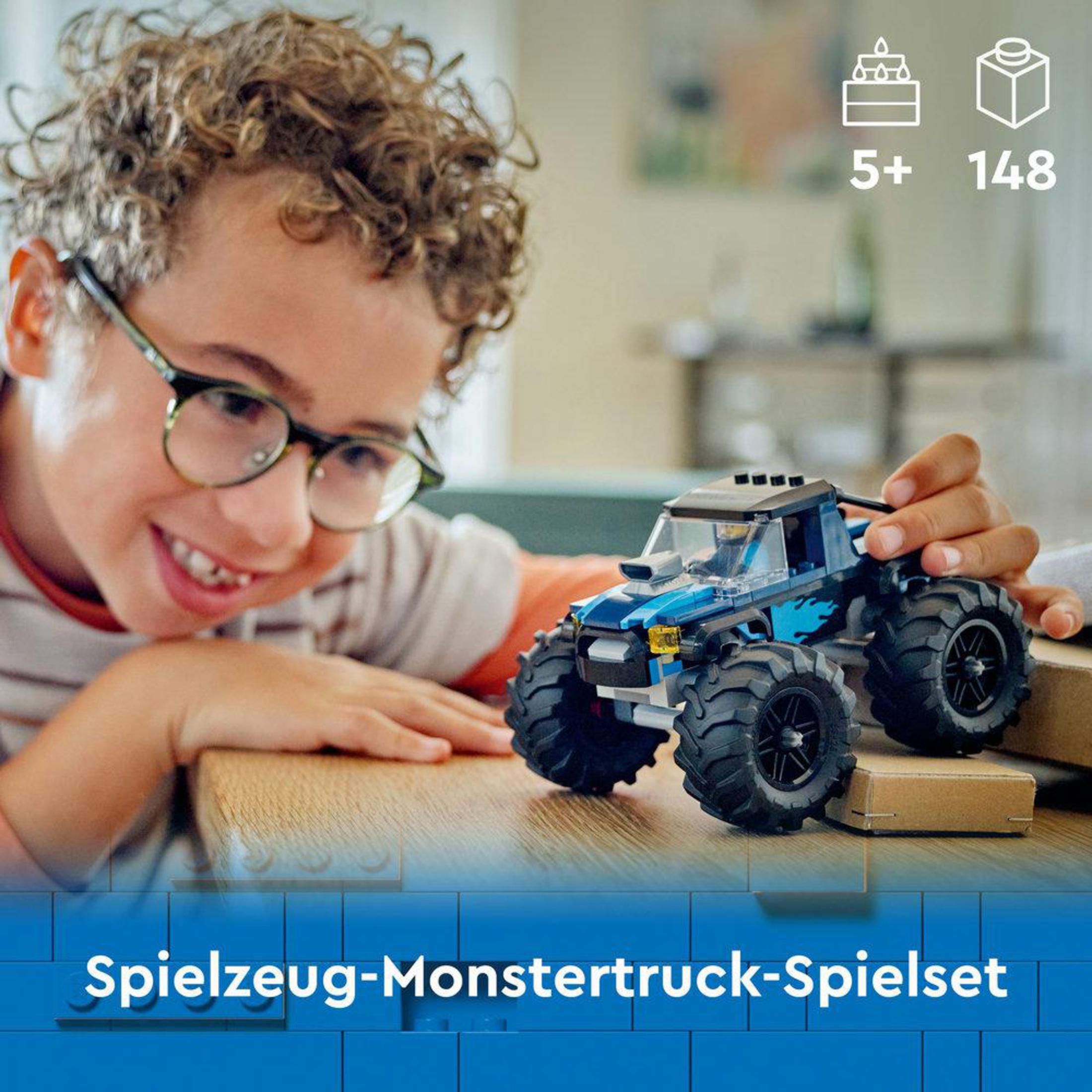 Bir Lego canavar kamyon oyuncağıyla oynayan güler yüzlü bir çocuk. Oyuncak büyük lastiklere sahip.
