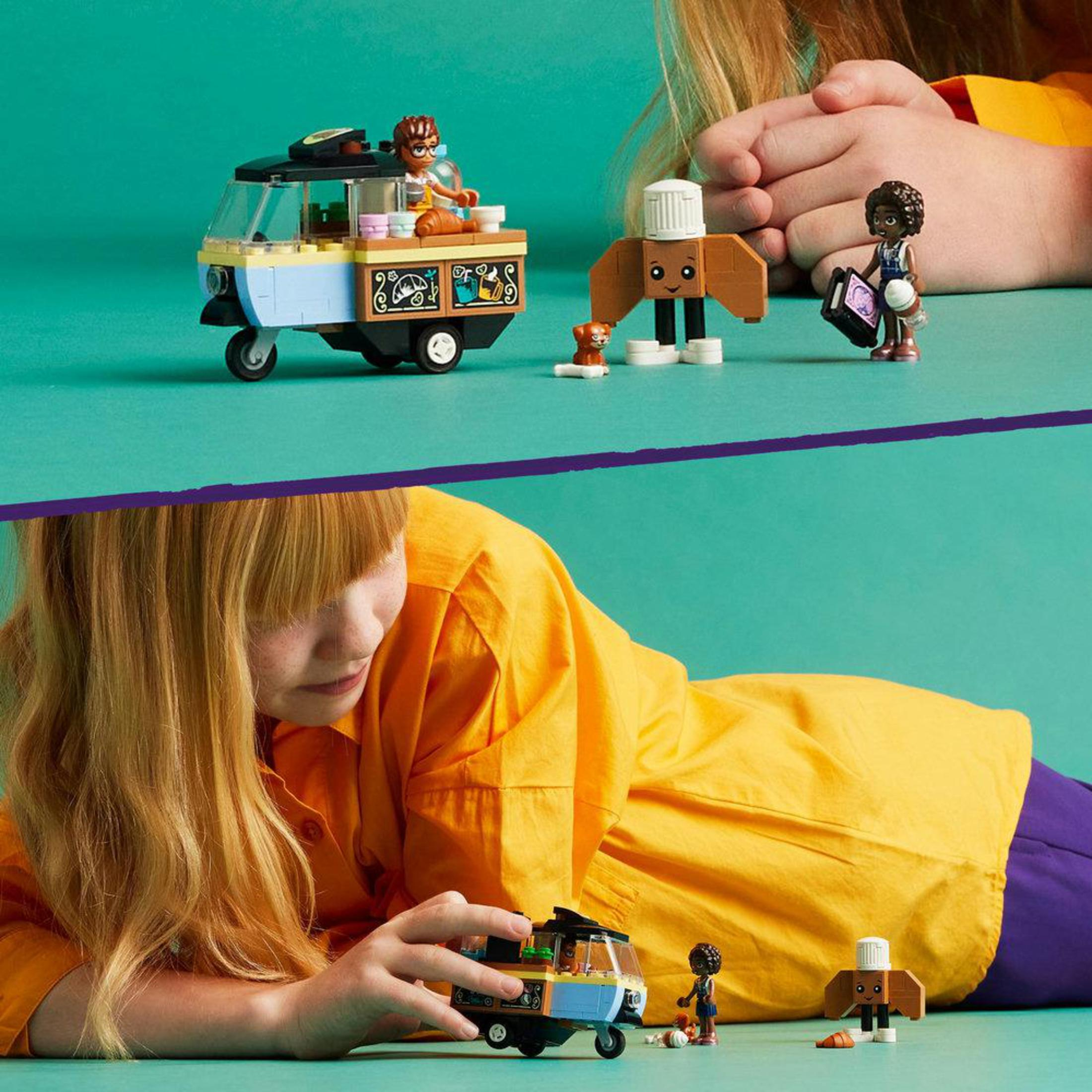 Een Lego set met een foodtruck en figuren. Het bevat een meisje, een jongen, een hond en een kok.