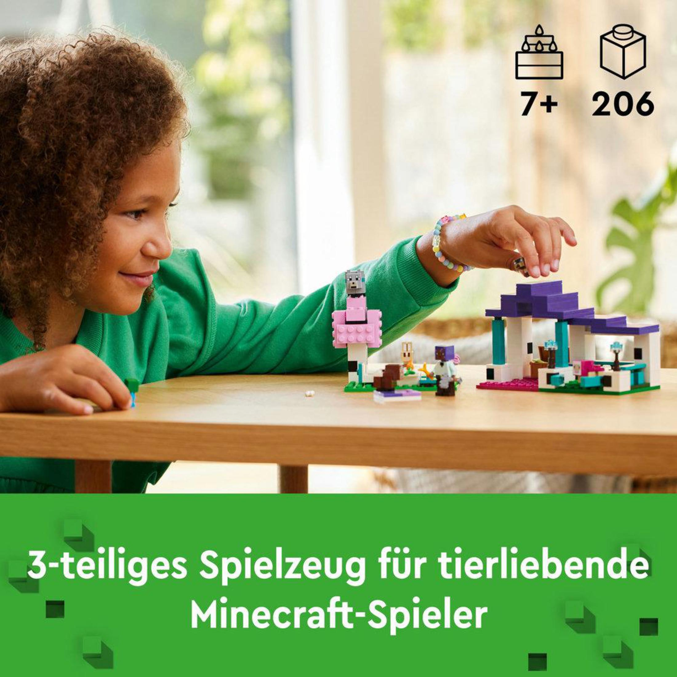 Una ragazza gioca con un set Lego. Il set include una casa e personaggi di Minecraft. 7+ anni.