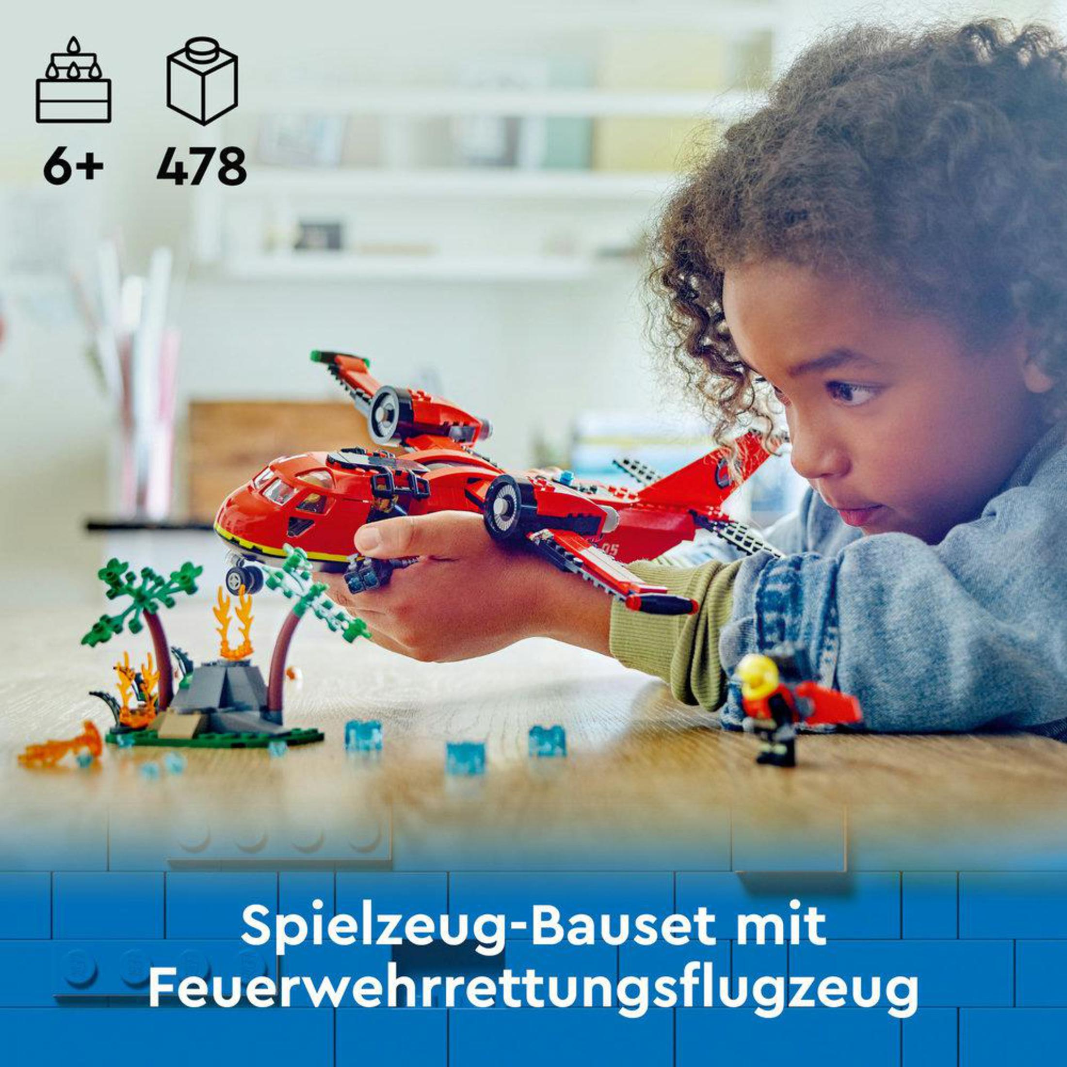 Un niño jugando con un set de avión de rescate de bomberos Lego. El avión es rojo.