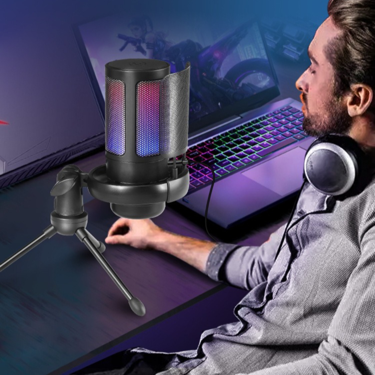 Mann mit Headset, Mikrofon, Laptop. Mikrofon hat blaue und rote Lichter. Der Schreibtisch ist schwarz.