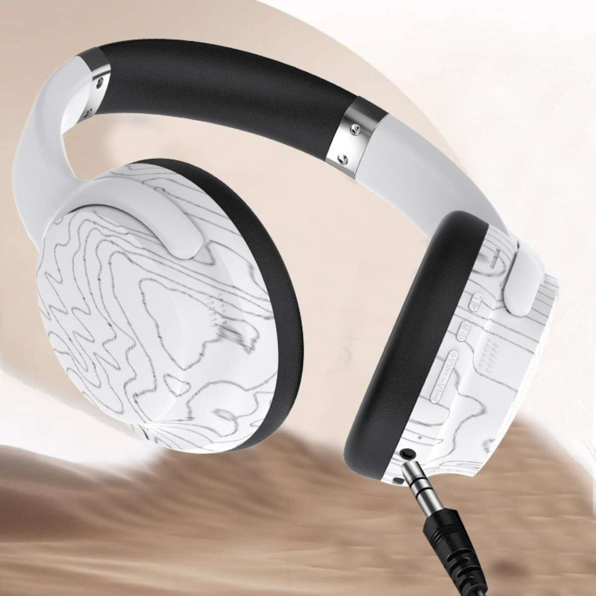 Weiße Kopfhörer mit schwarzem Band. Die Ohrmuscheln haben ein topografisches Kartendesign und eine 3,5-mm-Buchse.