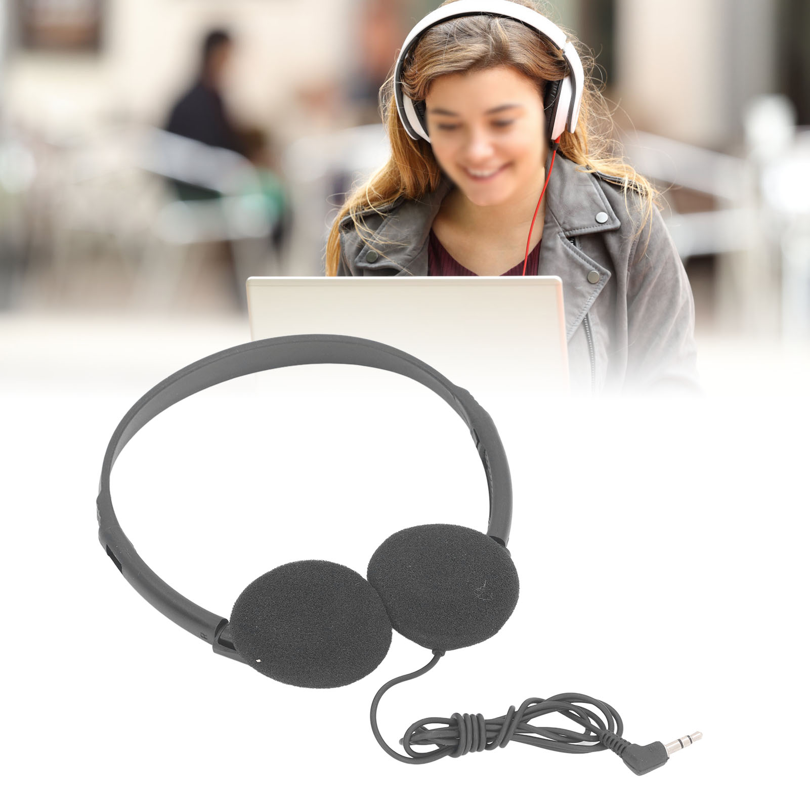 Kopfhörer mit Ohrmuscheln und Kabel im Vordergrund. Eine verschwommene Frau lächelt im Hintergrund.