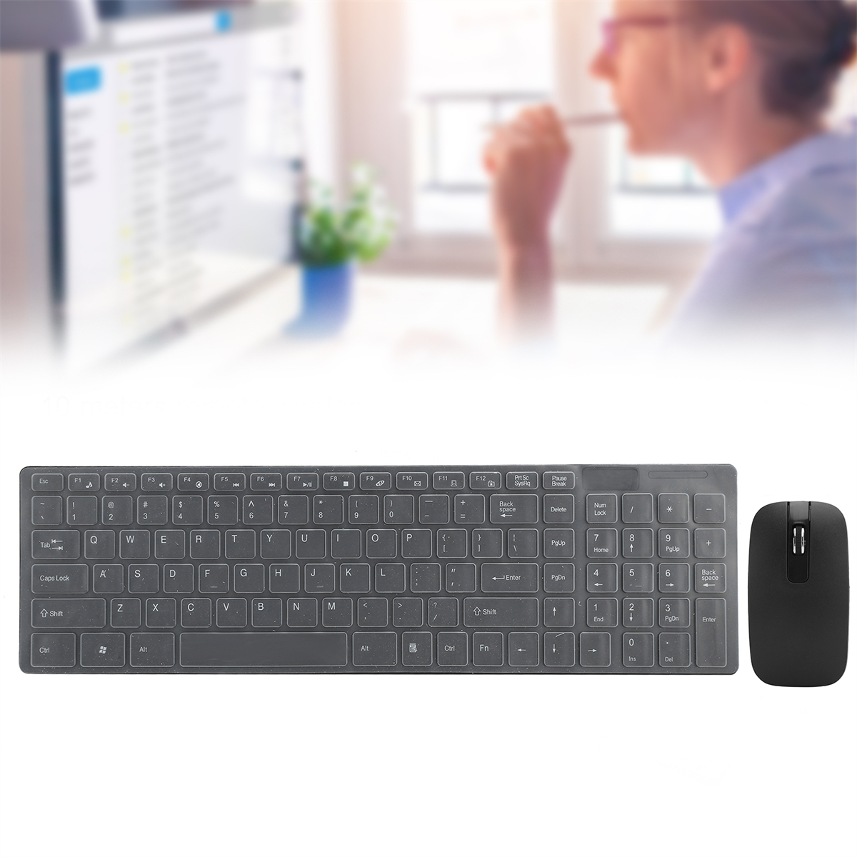 Tastatur und Maus auf einem Schreibtisch, mit einer verschwommenen Person im Hintergrund.