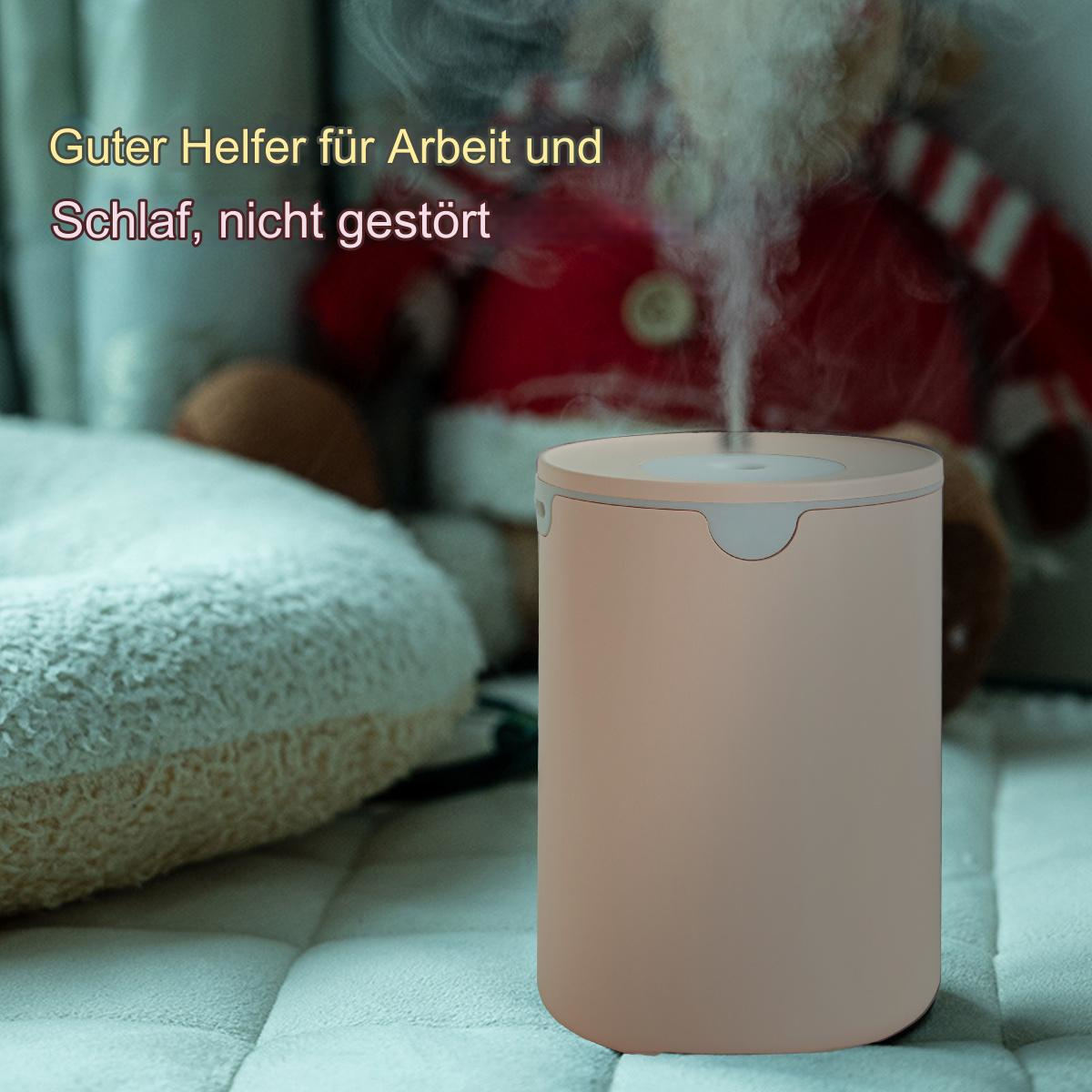 Ein beigefarbener Luftbefeuchter, der Dampf abgibt, auf einem grauen Bett. Ein Kissen ist ebenfalls sichtbar.