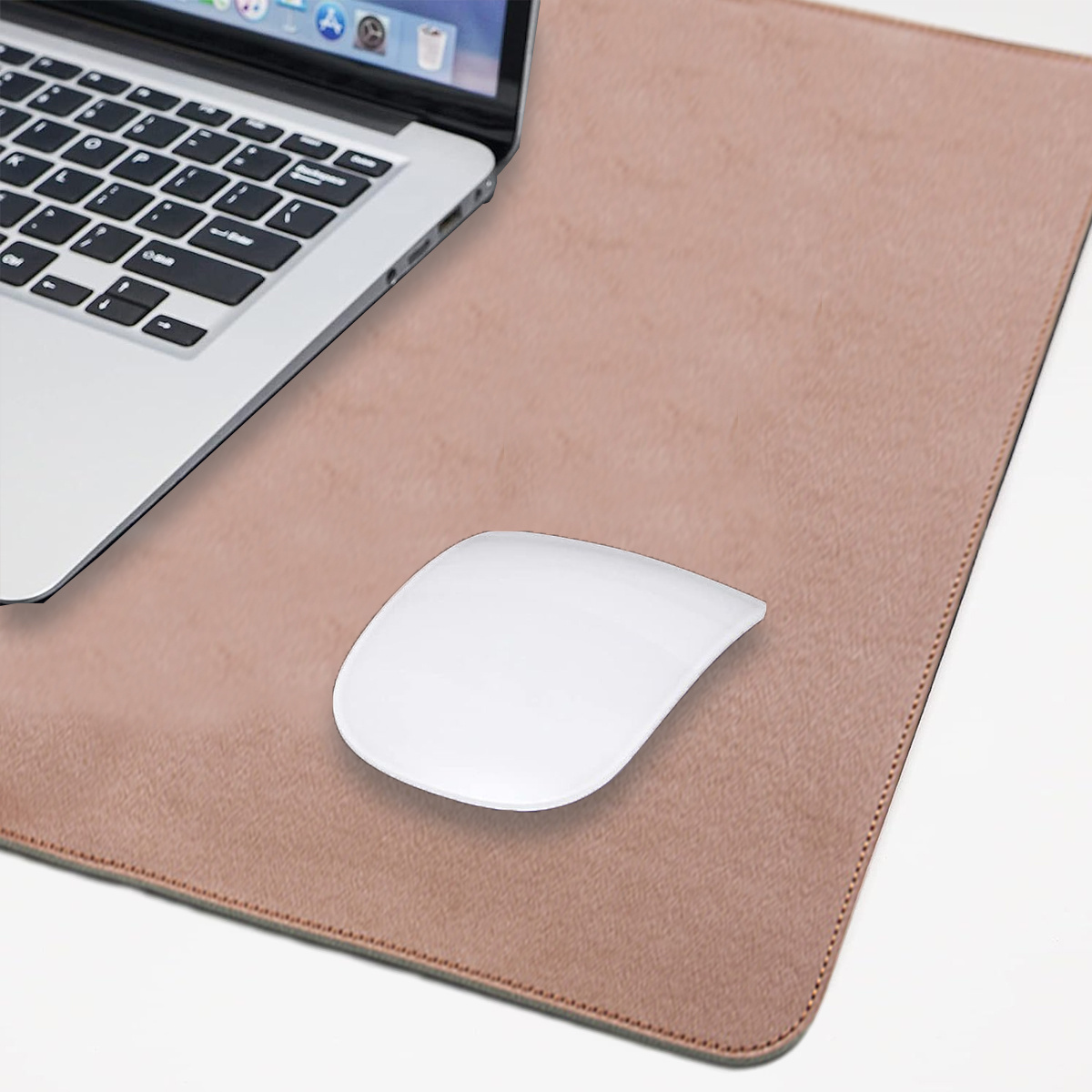 Ein Laptop auf einem rosa Mousepad mit einer weißen Maus.