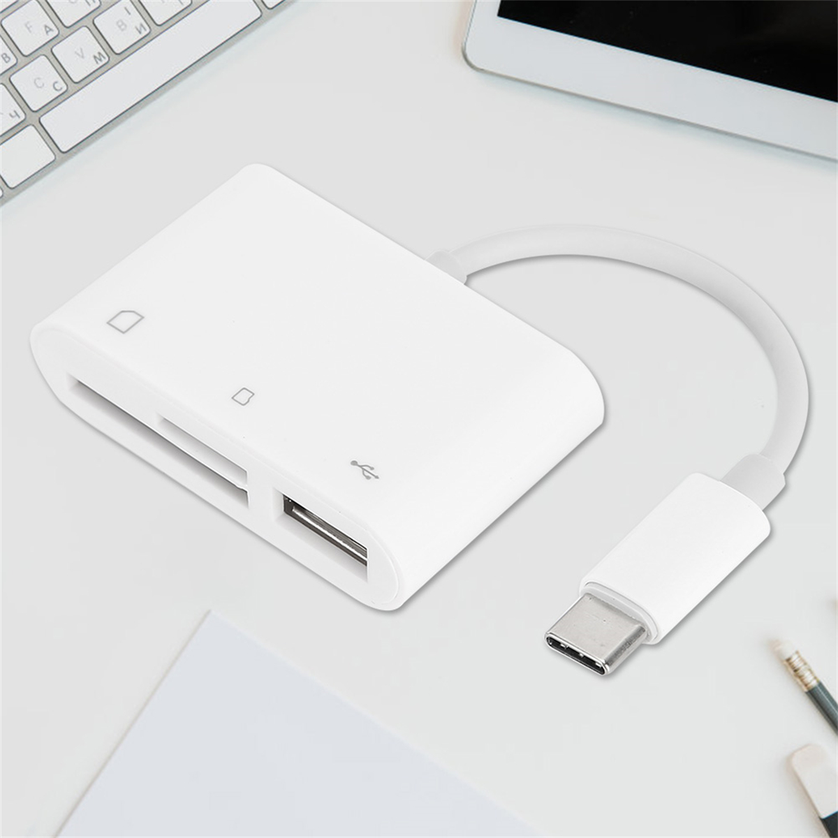 Ein weißer Kartenleser mit USB-C-Kabel und -Anschluss. Er liegt auf einem weißen Schreibtisch mit anderen Objekten.