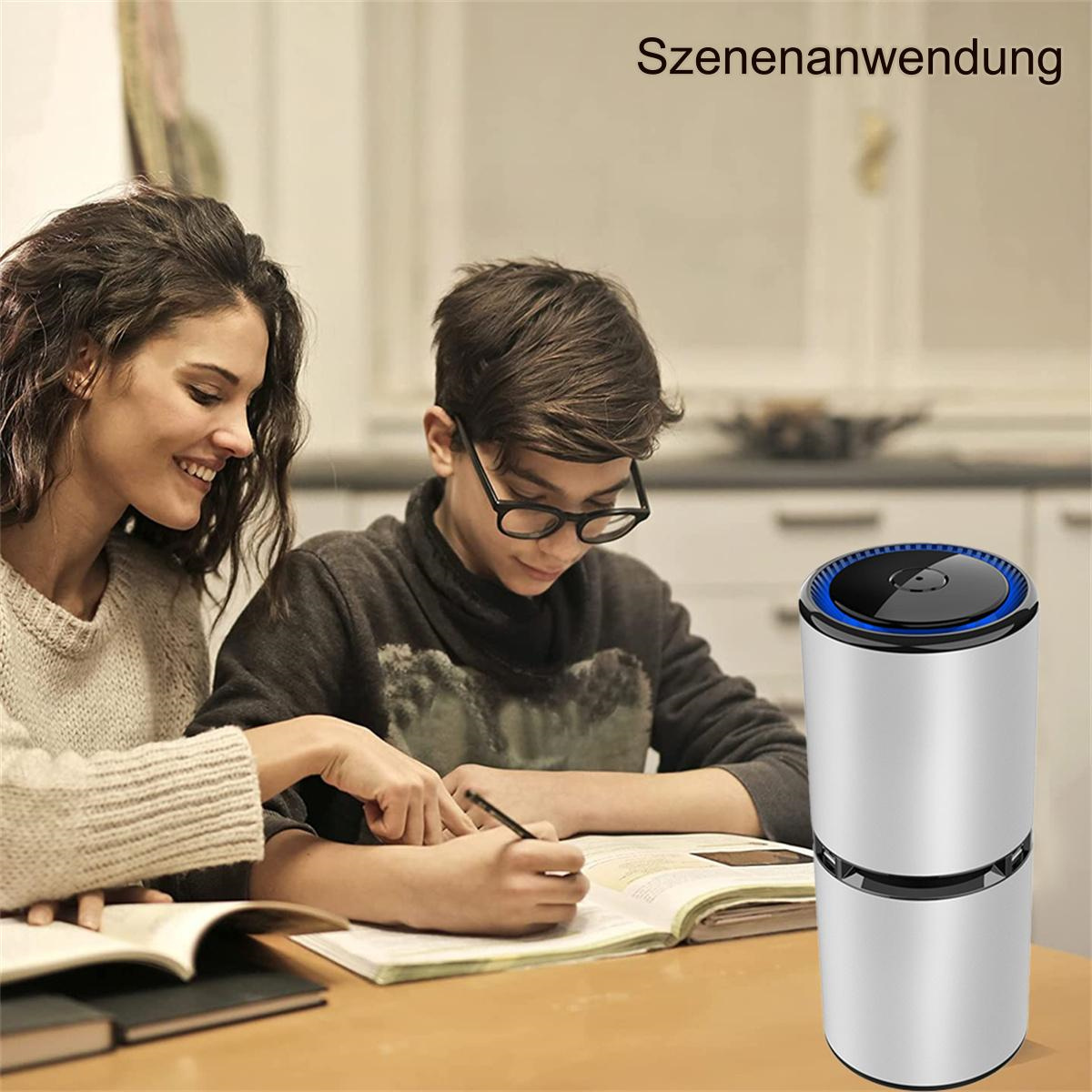 Eine Frau und ein Junge sitzen an einem Tisch, der Junge schreibt, ein Luftreiniger steht auf dem Tisch.