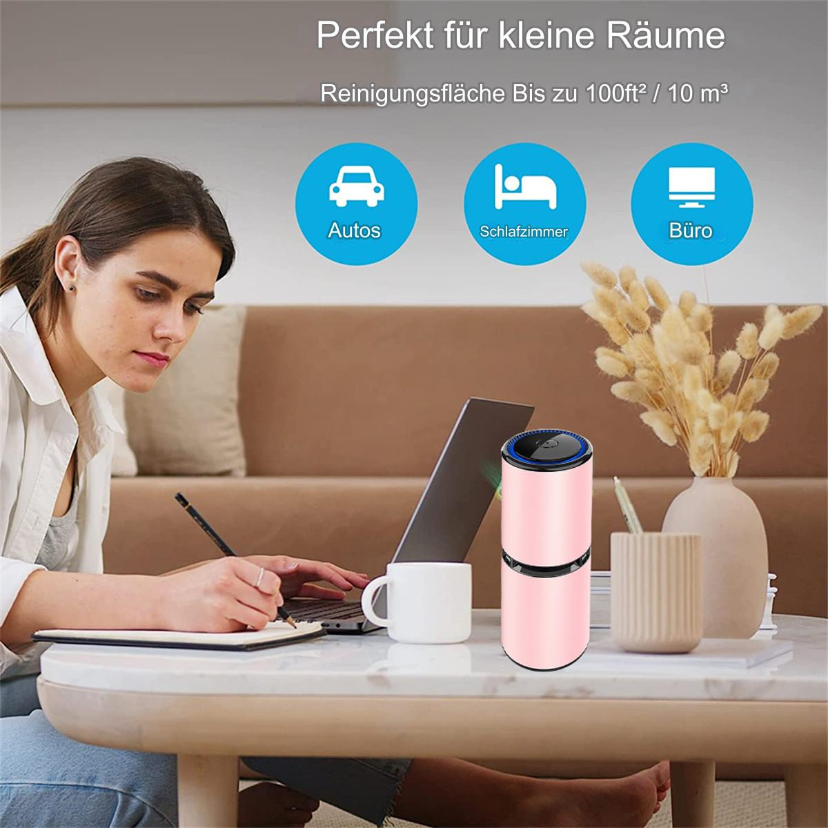 Eine Frau arbeitet am Laptop, mit einem rosa Luftreiniger auf einem Tisch.