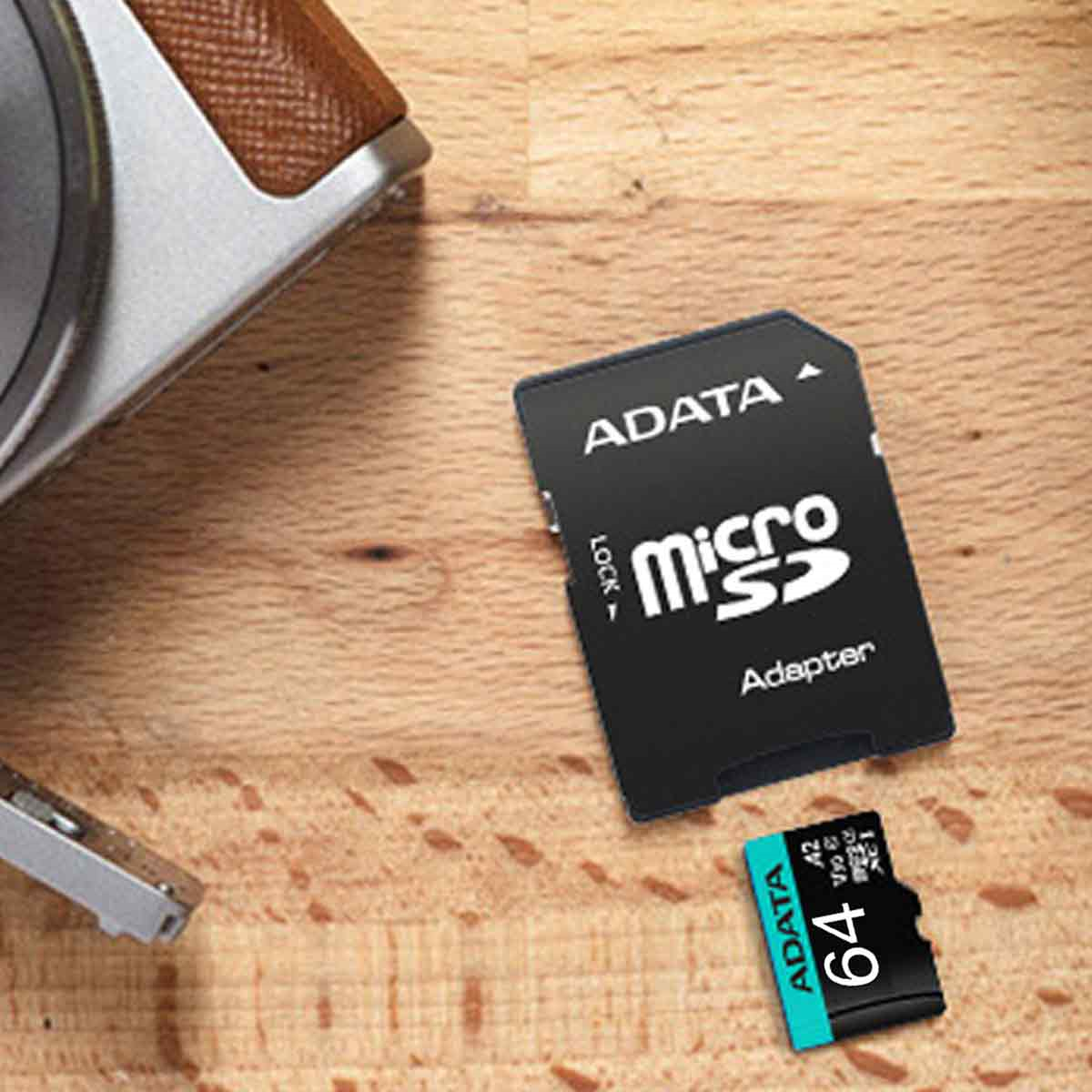 Micro-SD-Karte und Adapter auf Holztisch neben einer Kamera.