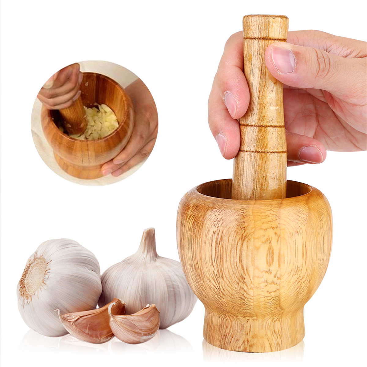Mörser und Stößel aus Holz mit Knoblauchzehen.