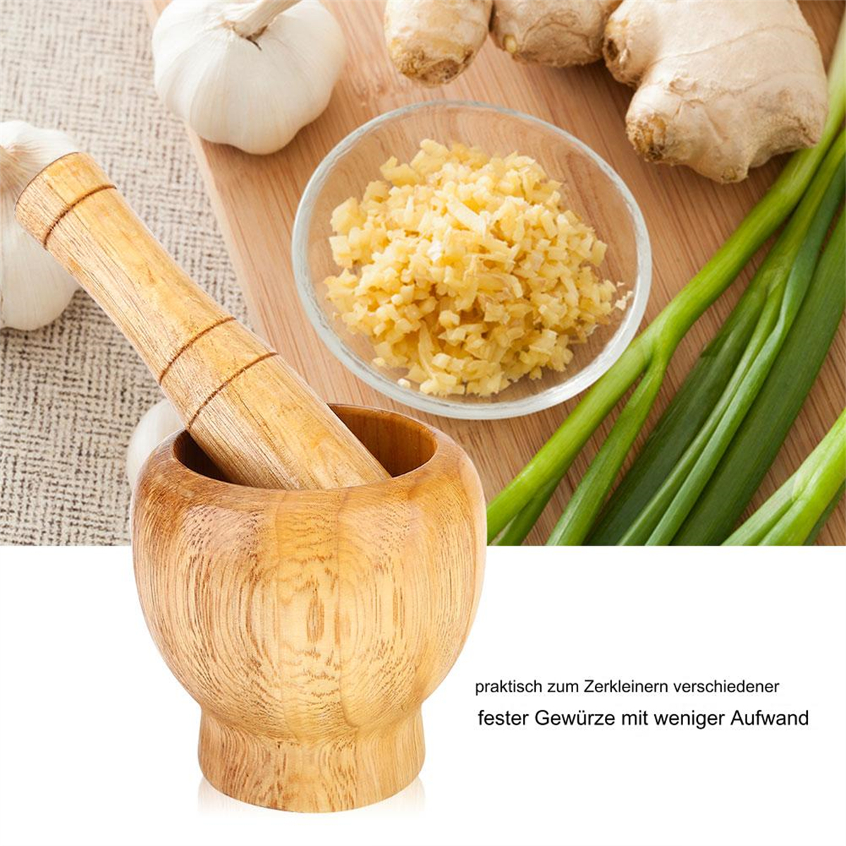 Mörser und Stößel mit Knoblauch, Ingwer und Frühlingszwiebeln auf Holzbrett.