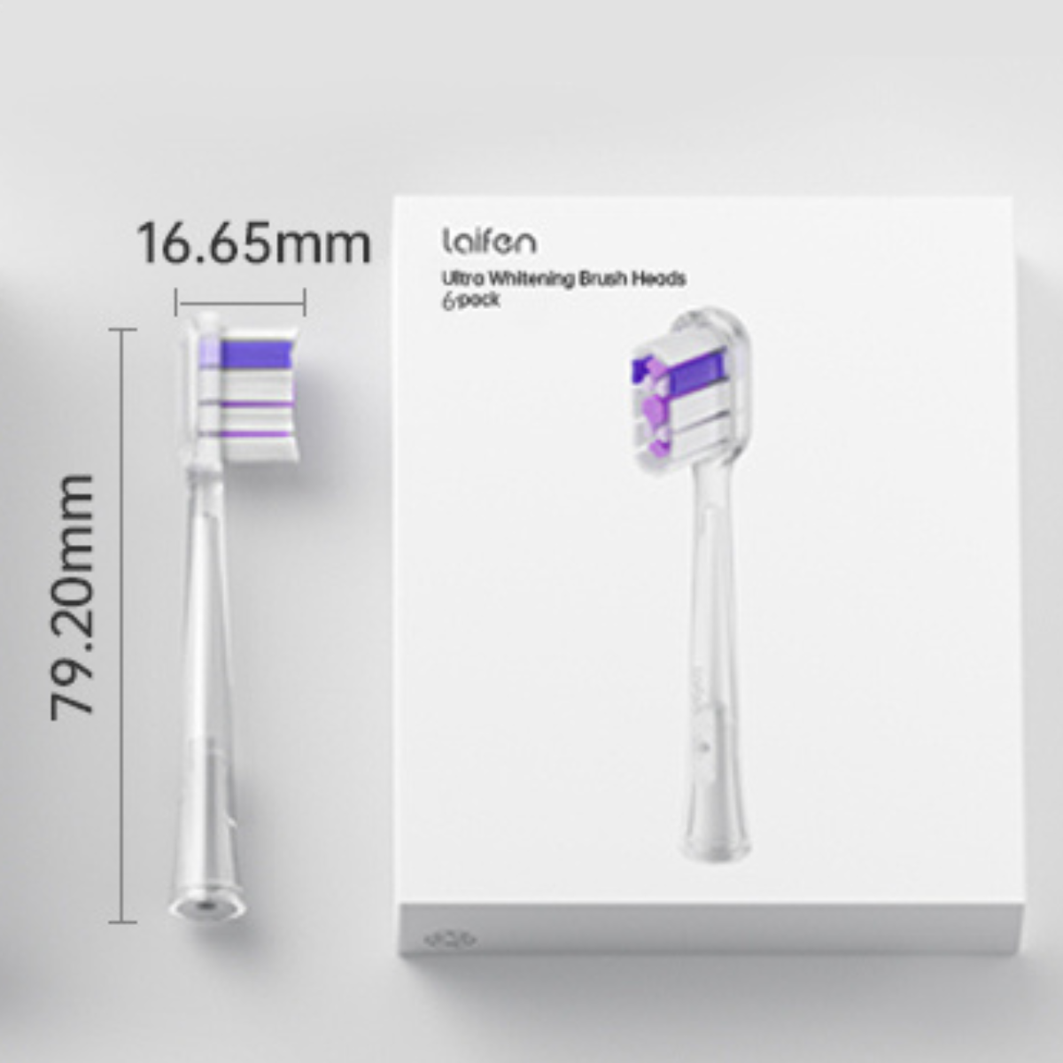 Główka szczoteczki do zębów obok pudełka z tą samą główką. Oba są białe z fioletowym i czarnym włosiem.