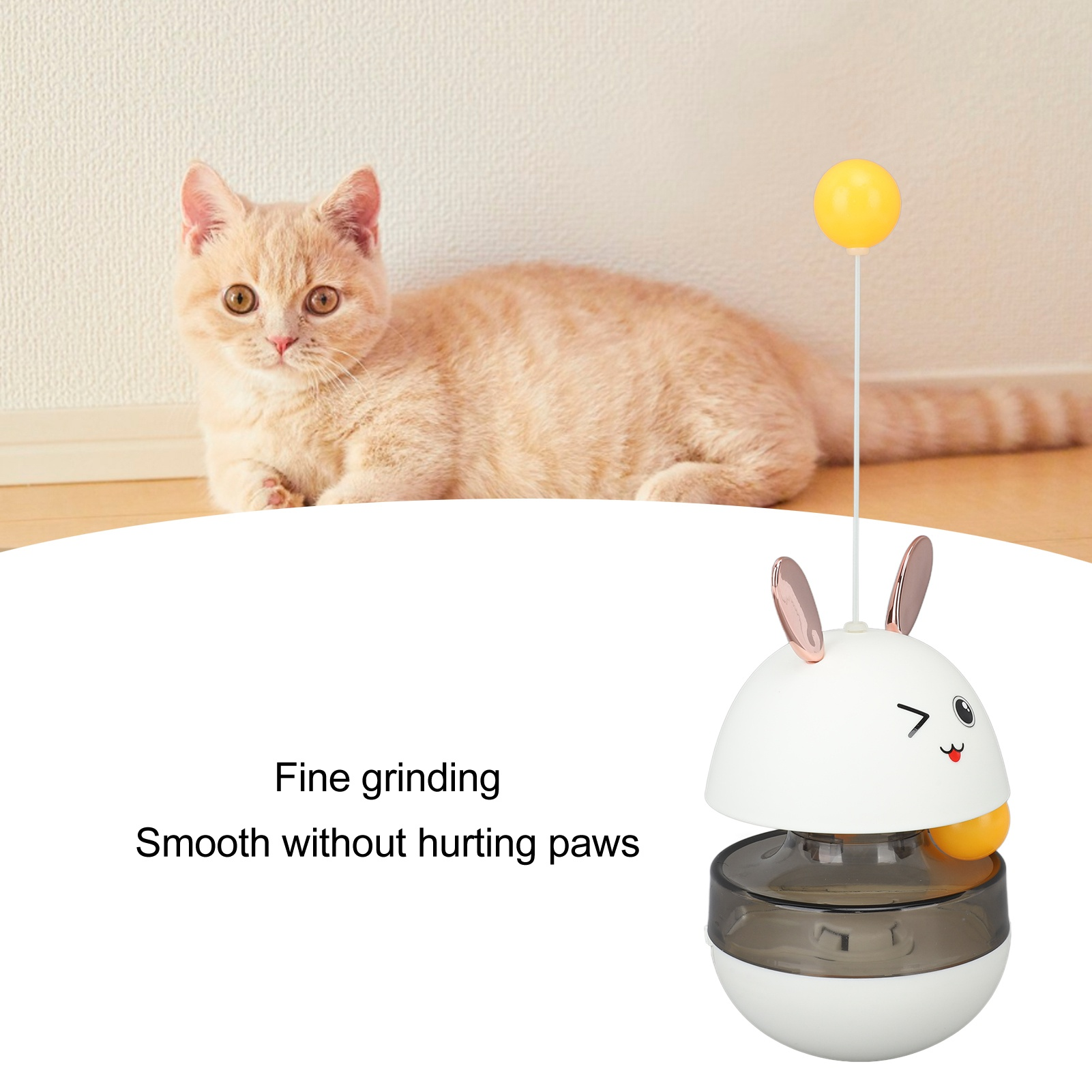 Ein Katzenspielzeug in Hasenform mit gelbem Ball, und eine Katze daneben.