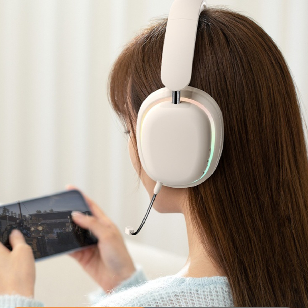Eine Frau mit weißen Kopfhörern hält ein Handy mit einem Spiel auf dem Bildschirm.