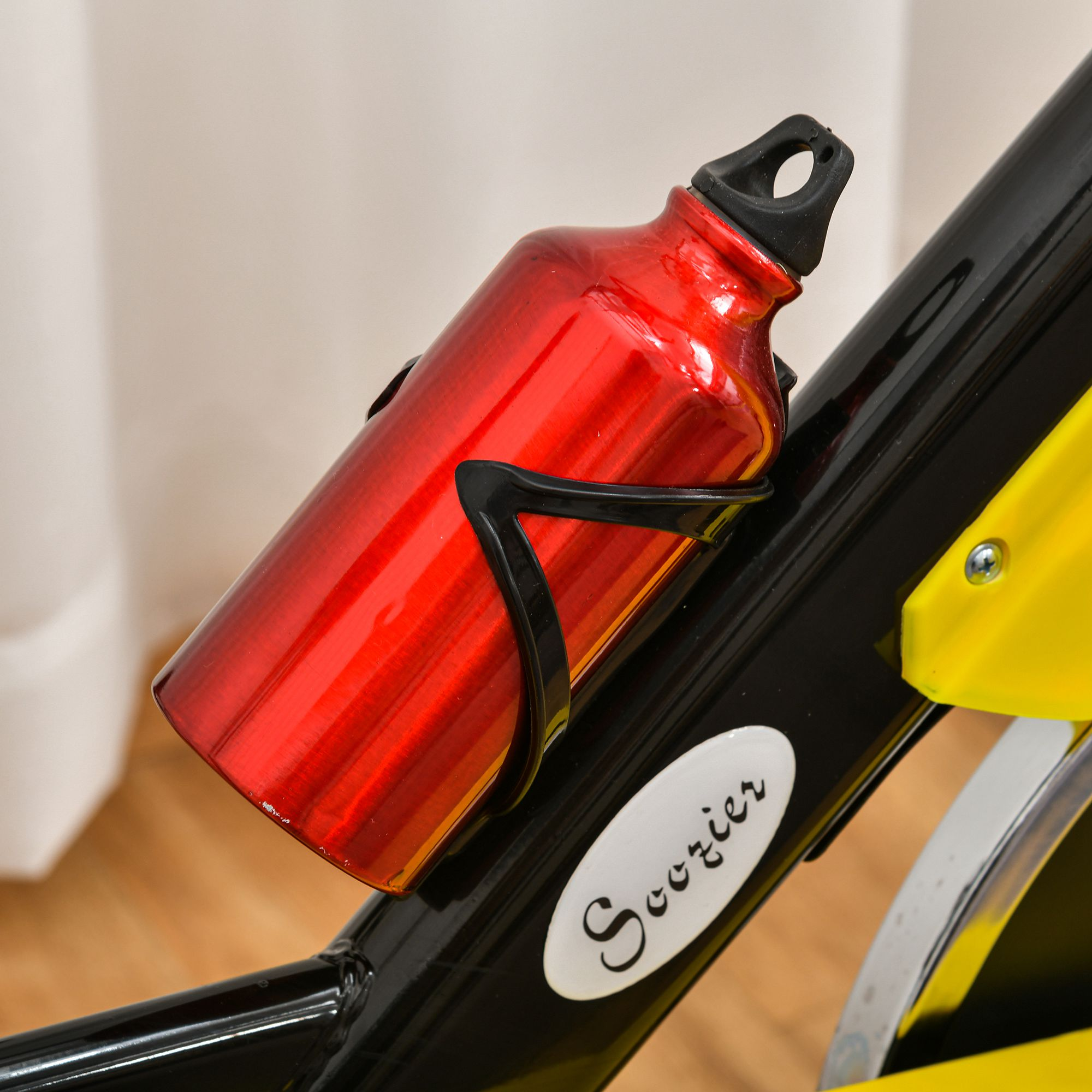 Rote Wasserflasche in einem schwarzen Halter an einem Heimtrainer.