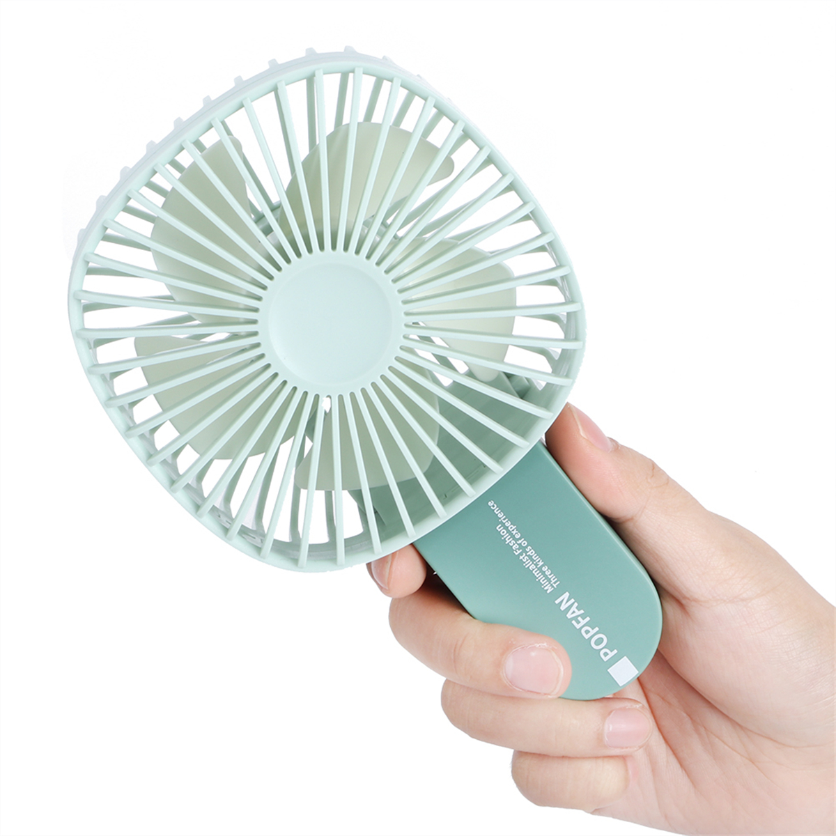 Ein hellgrüner Handventilator wird von einer Hand gehalten. Er hat einen kreisförmigen Lüfter und einen grünen Griff.