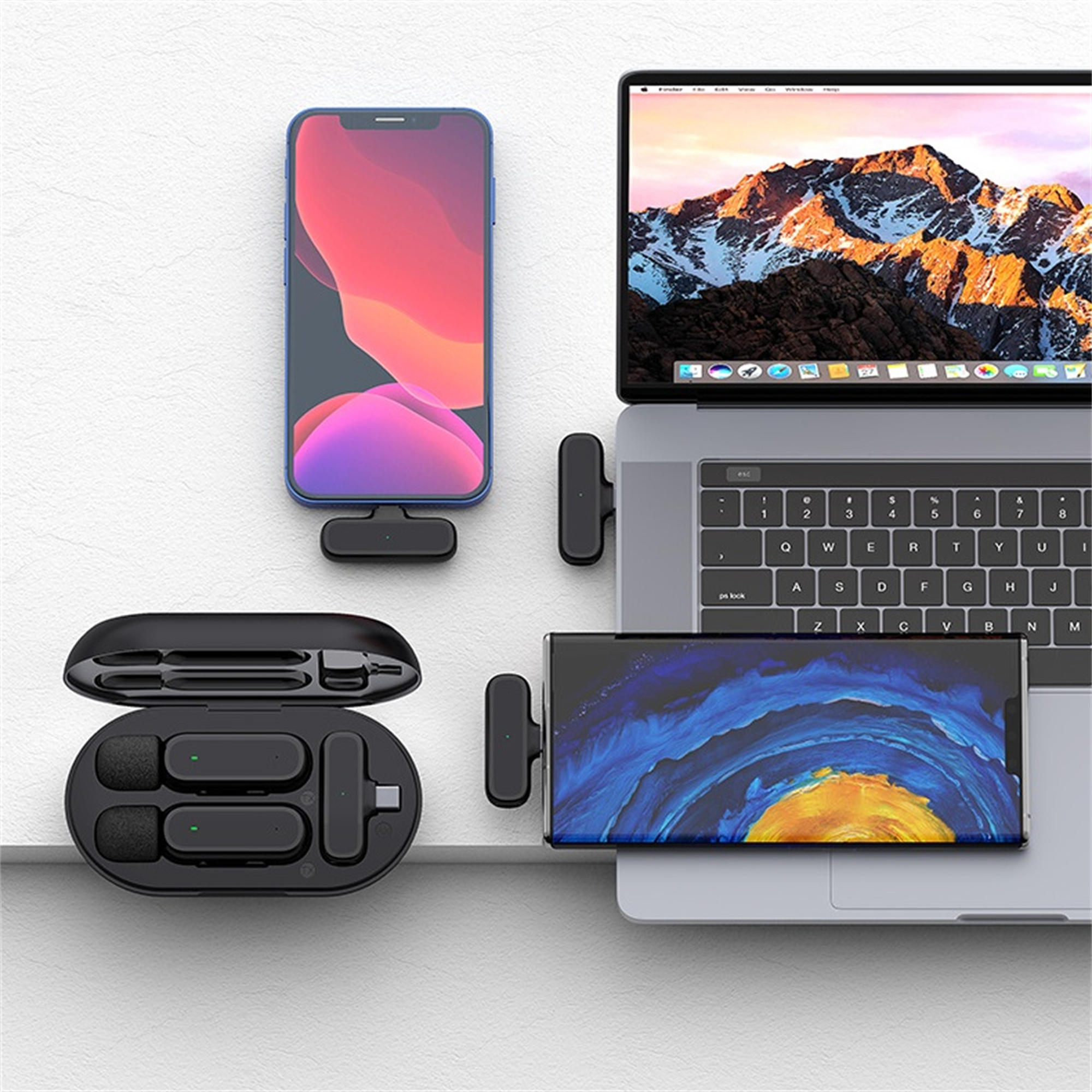 Geräte auf weißer Oberfläche: Telefon, Laptop und zwei Paare kabelloser Ohrhörer. Schwarz und blau.